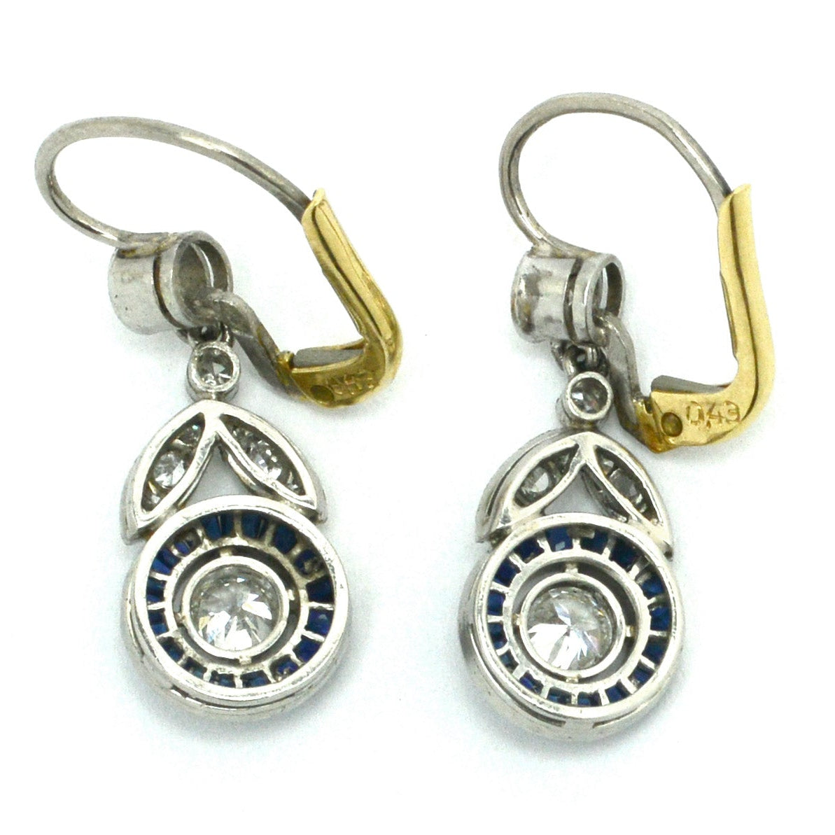 The finely detailed milgrain bezel and the calibre' and French cut halo of blue sapphires.