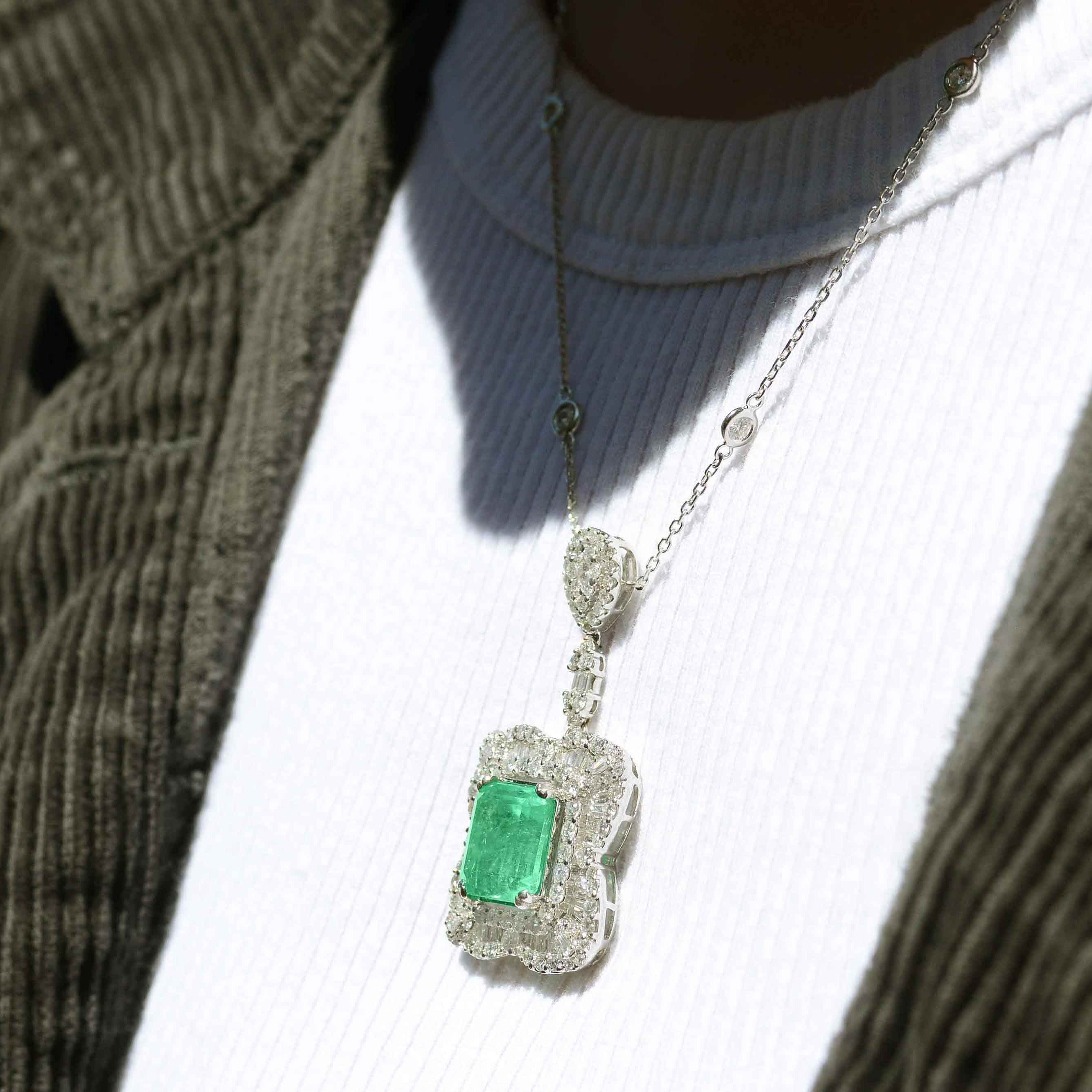 The emerald is surrounded by 3 carats of glittering and fiery baguette and round diamonds in a pave' ballerina setting.