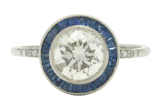 One and half carat diamond engagement ring with sapphire halo.