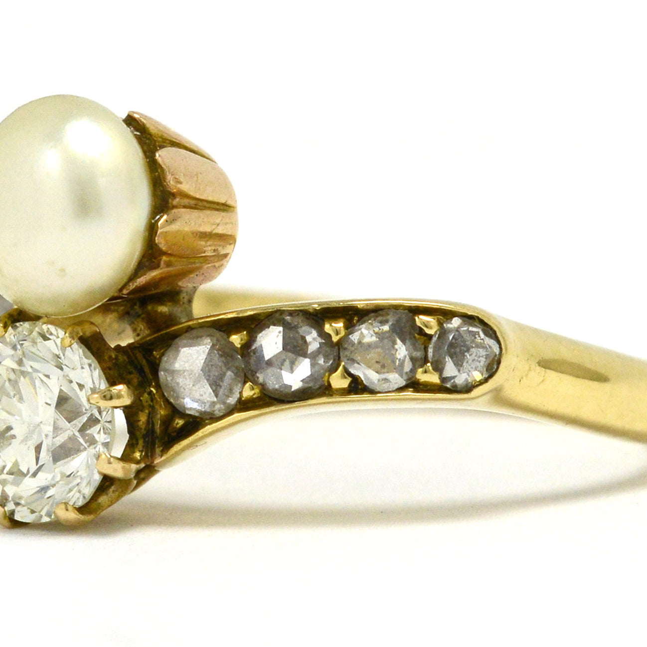An Art Nouveau diamond and pearl two stone engagement ring.