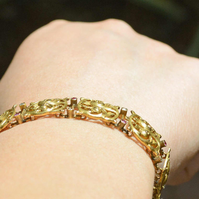 This link bracelet is accented with delicately set rubies and diamonds.