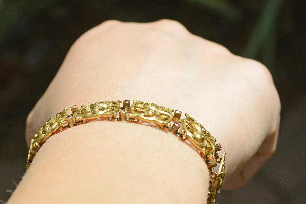 This link bracelet is accented with delicately set rubies and diamonds.