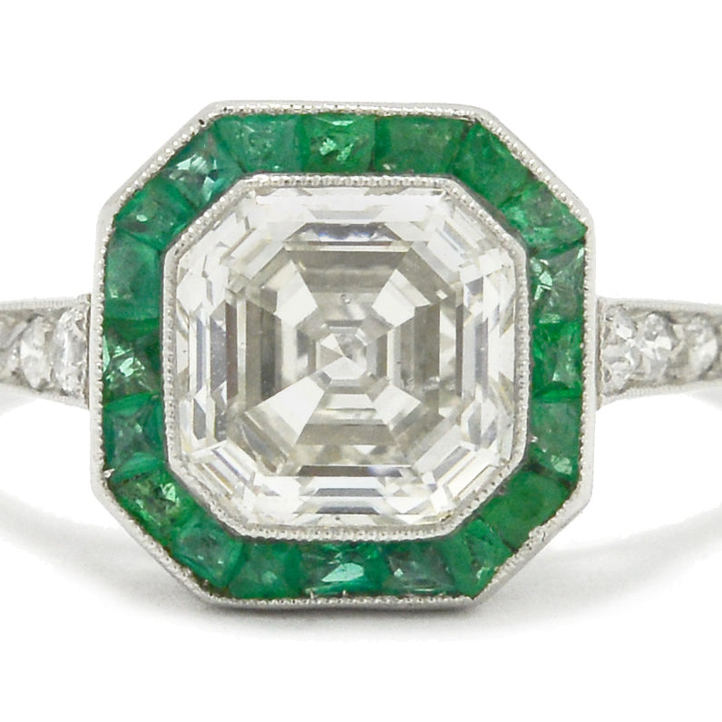 An Art Deco style platinum diamonds engagement ring with emeralds.