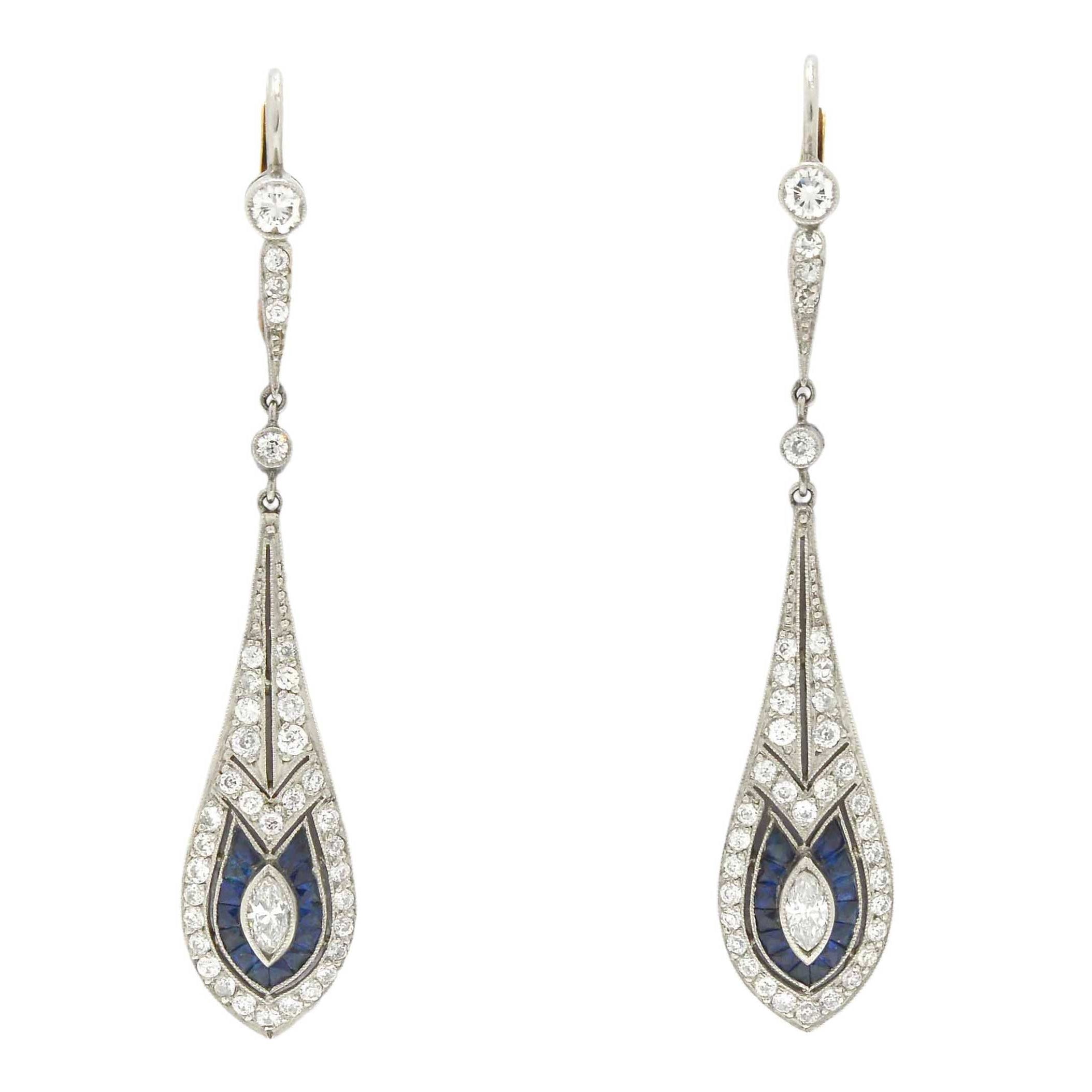 Diamond and blue sapphire dangle earrings created in the Art Deco style.