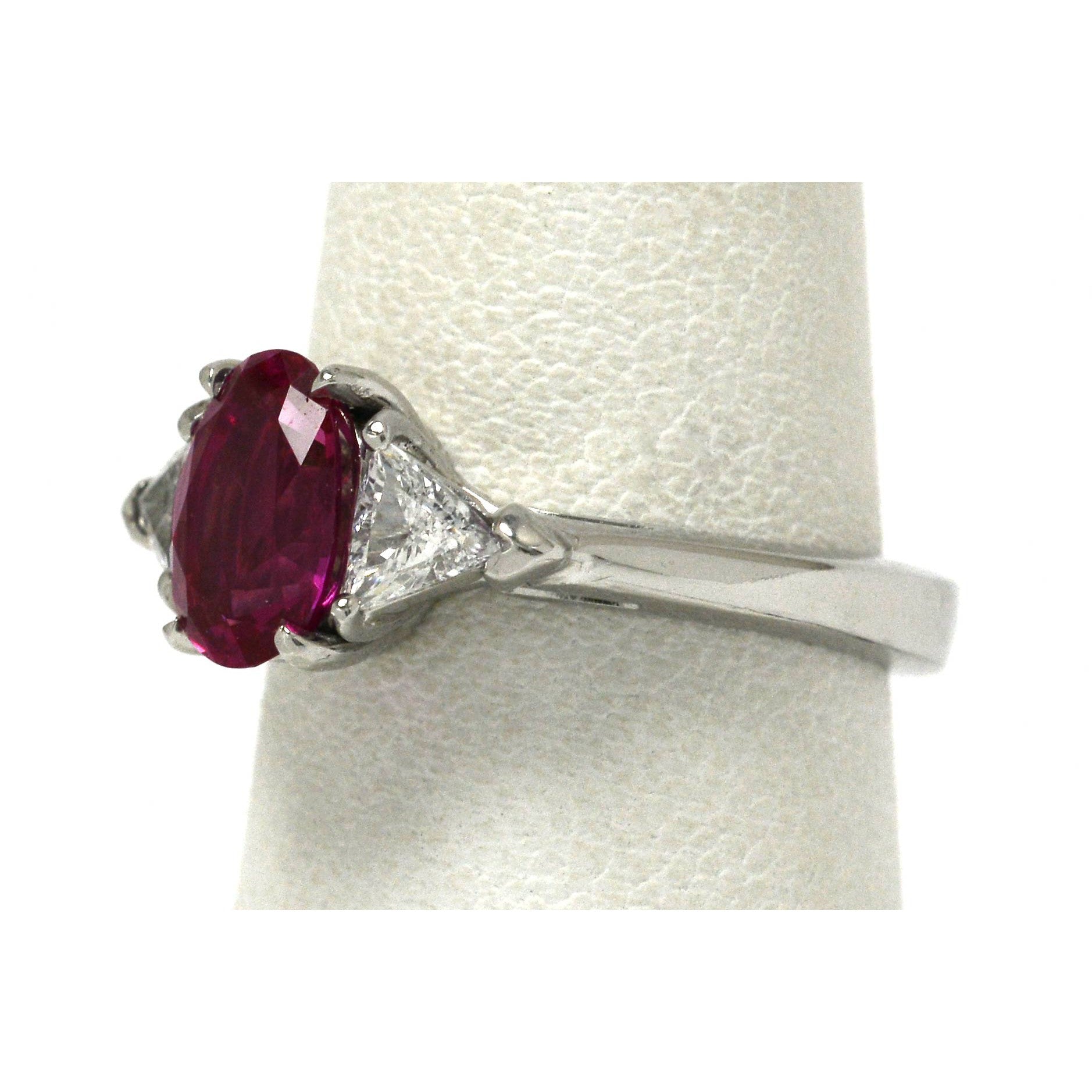 A 3 stone natural pink sapphire and 2 triangle diamonds engagement ring.