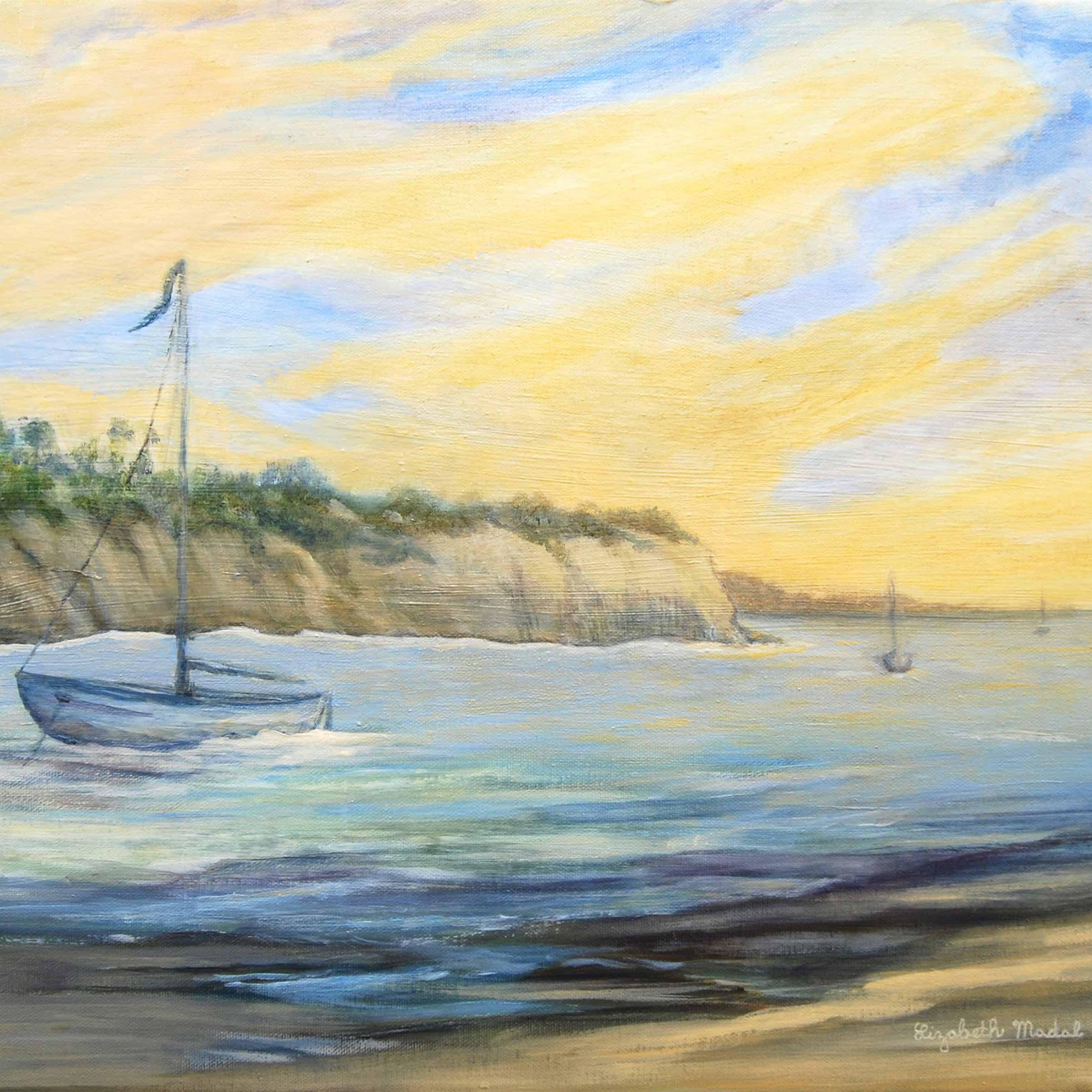 An anchored boat on shore with a blue and yellow sky.