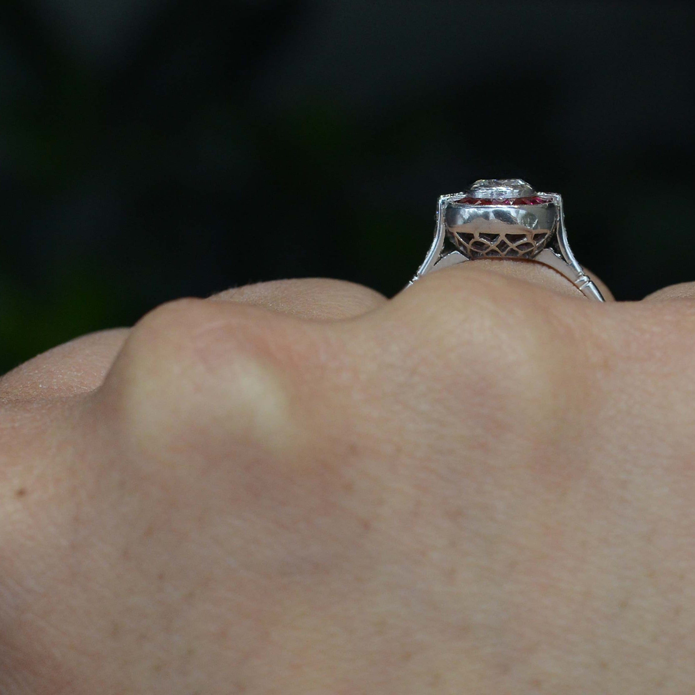 A honeycomb shaped filigree under gallery of a platinum engagement ring.
