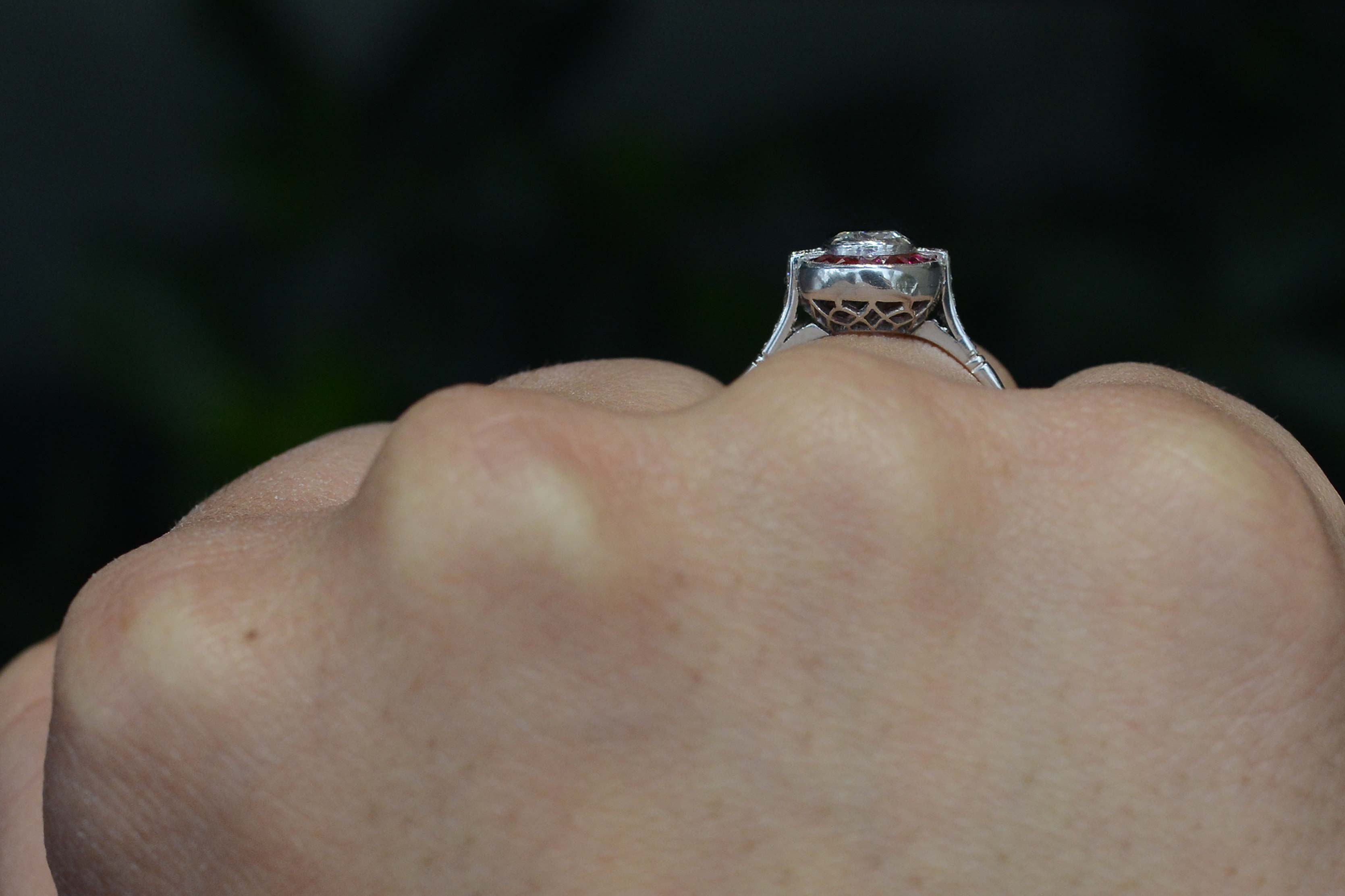 A honeycomb shaped filigree under gallery of a platinum engagement ring.