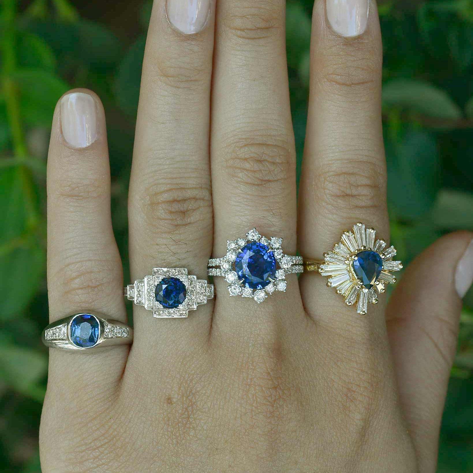 Round blue sapphire engagement rings with diamond halos.