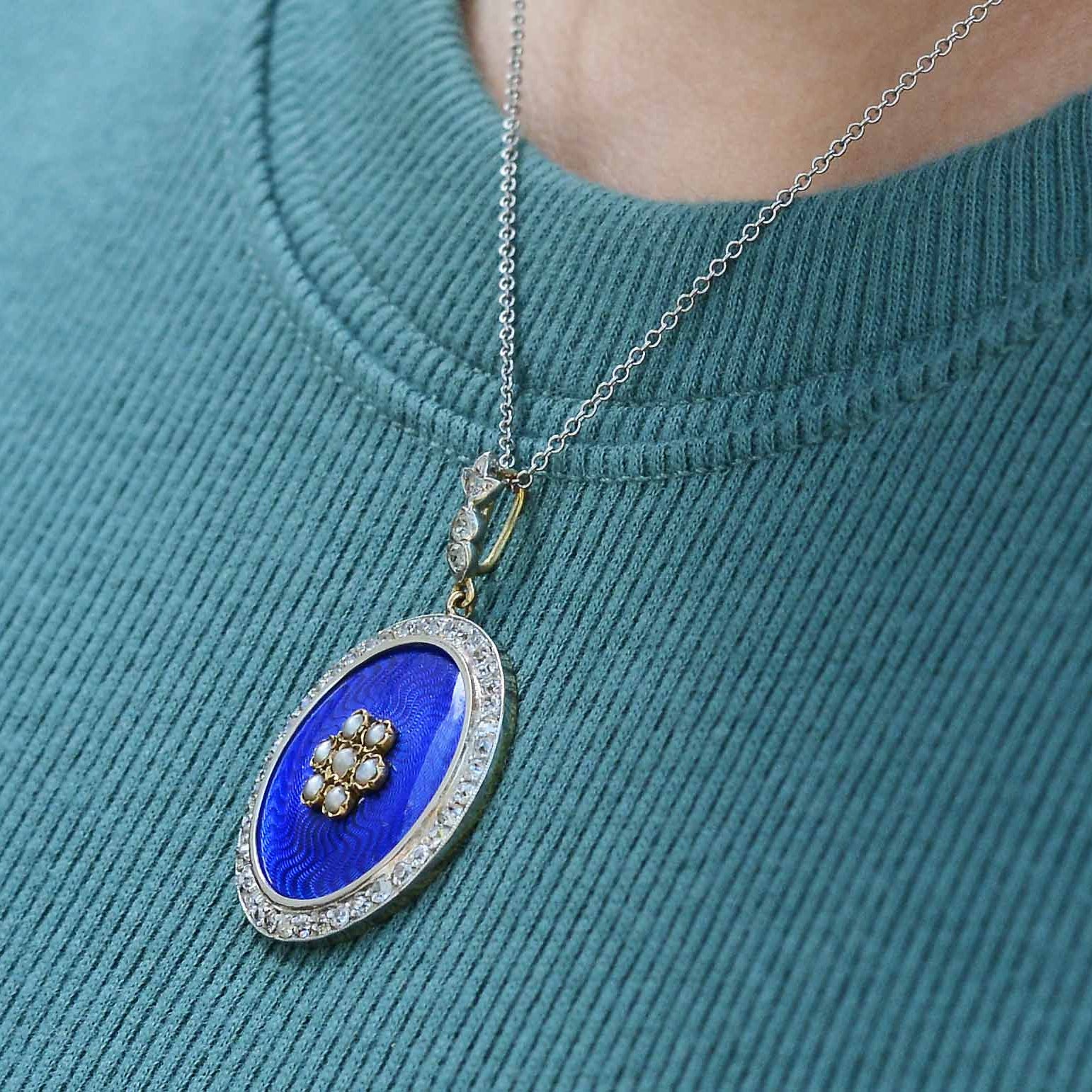 Rich, shimmering royal blue enamel lines this diamond halo pendant necklace.