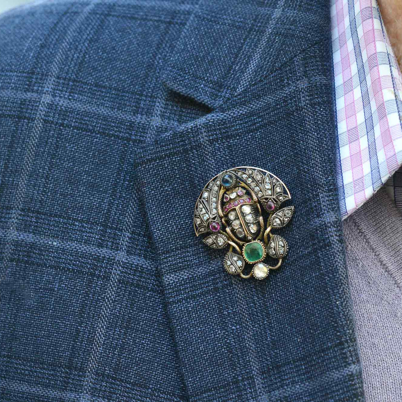This old scarab brooch is lined with diamonds, rubies, emerald and sapphire.