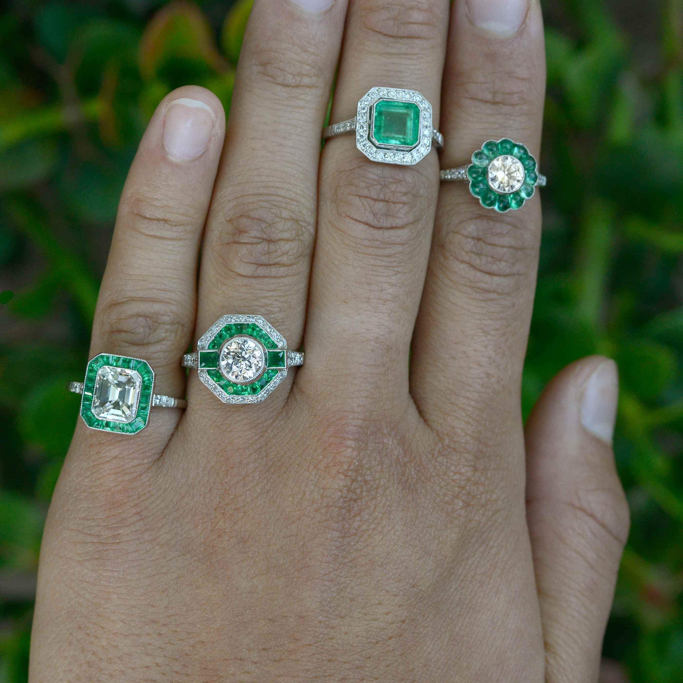 A collection of vintage and Art Deco style diamond and emerald halo engagement rings.