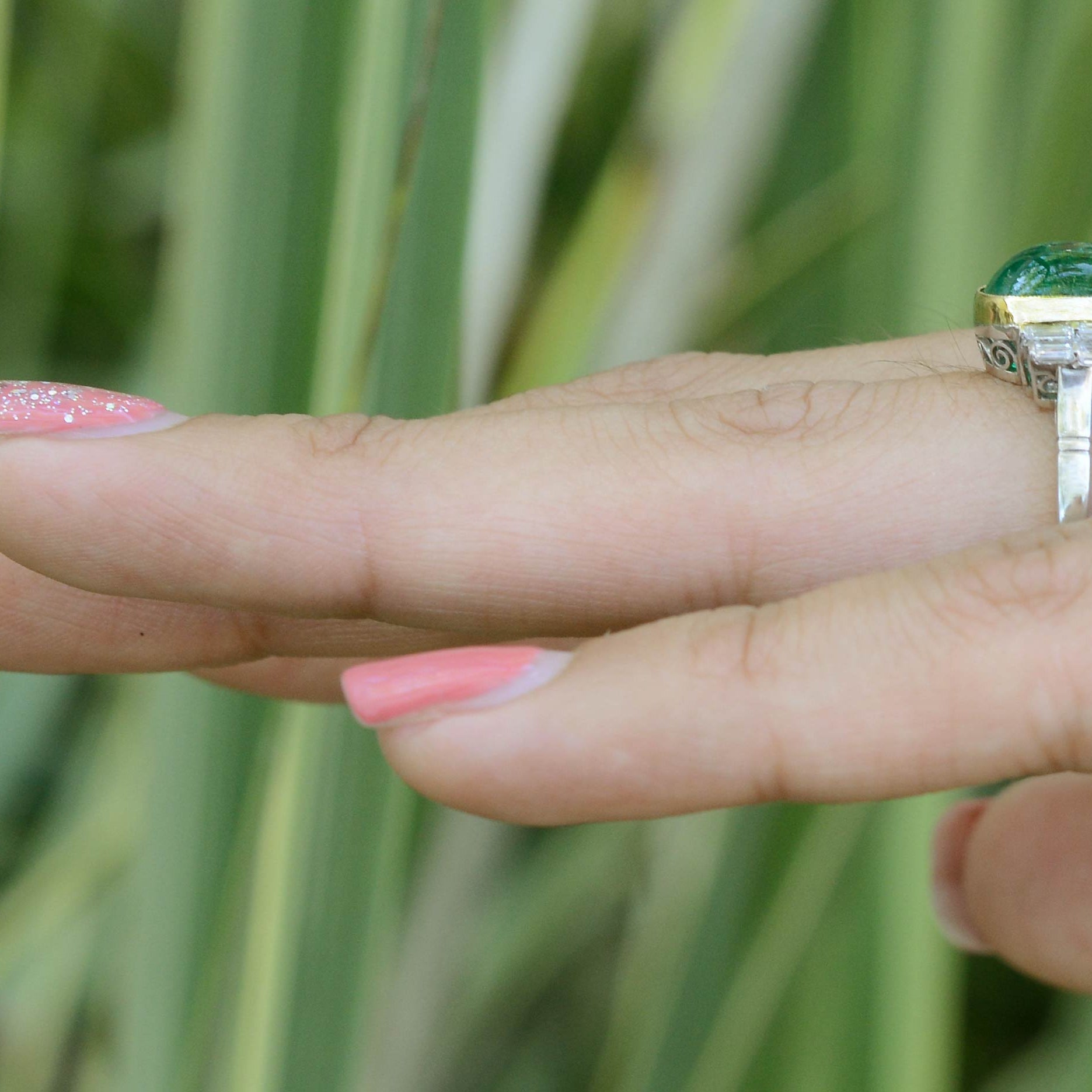 A cabochon cut Colombian emerald, platinum engagement ring with a gold bezel.
