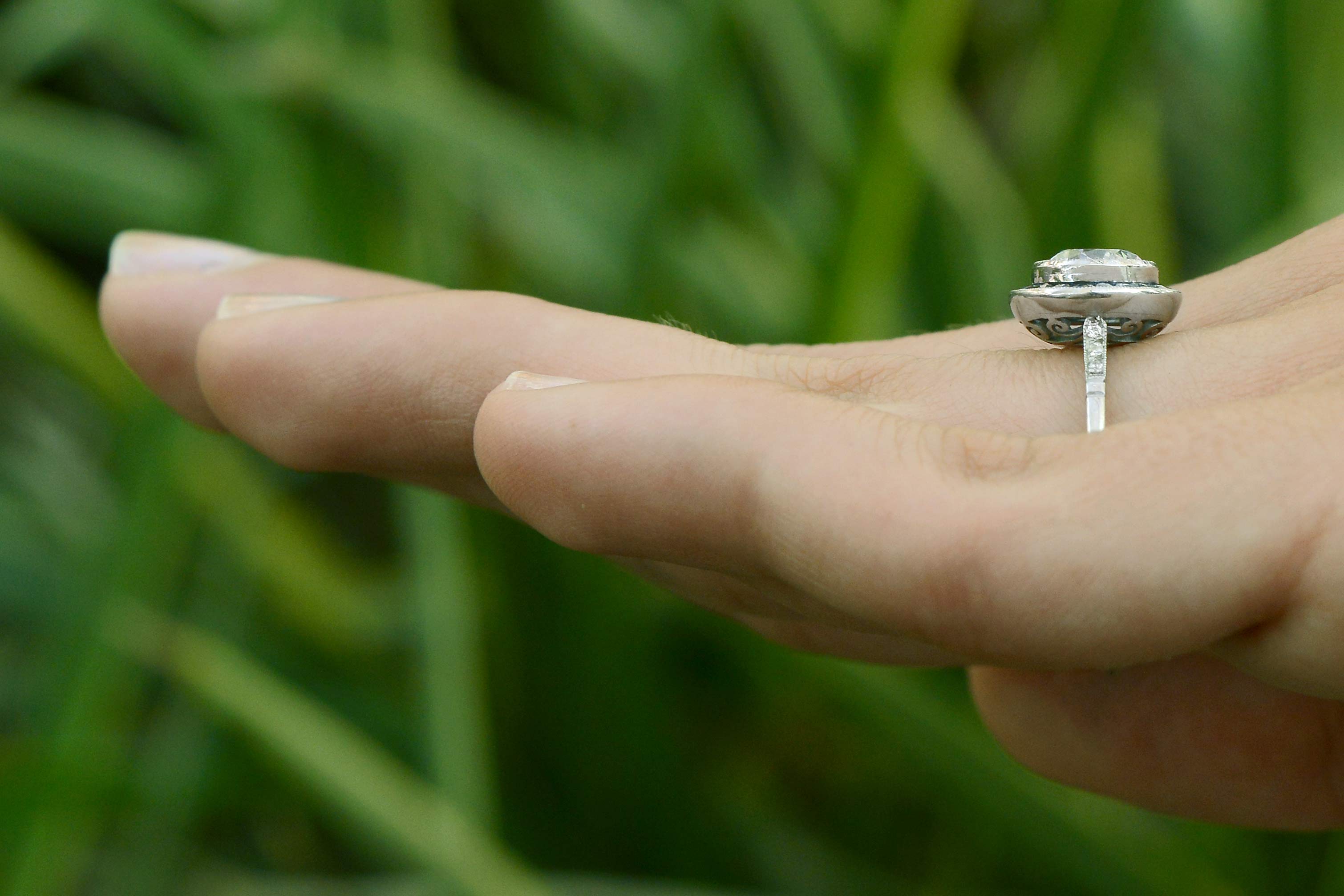 A round diamond, blue sapphire halo target engagement ring.