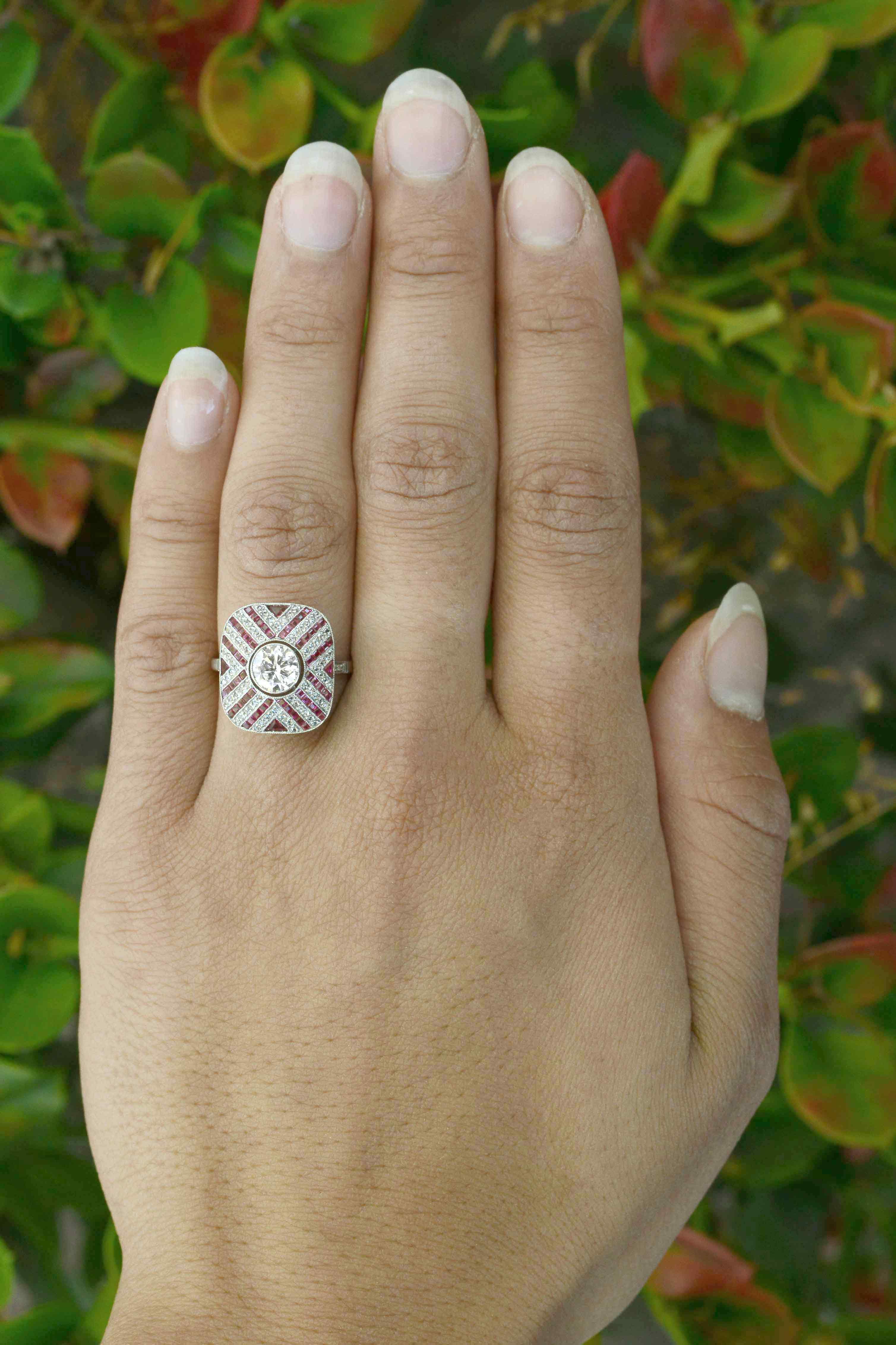 French cut rubies rose cut diamonds accent the center diamond in this engagement ring.