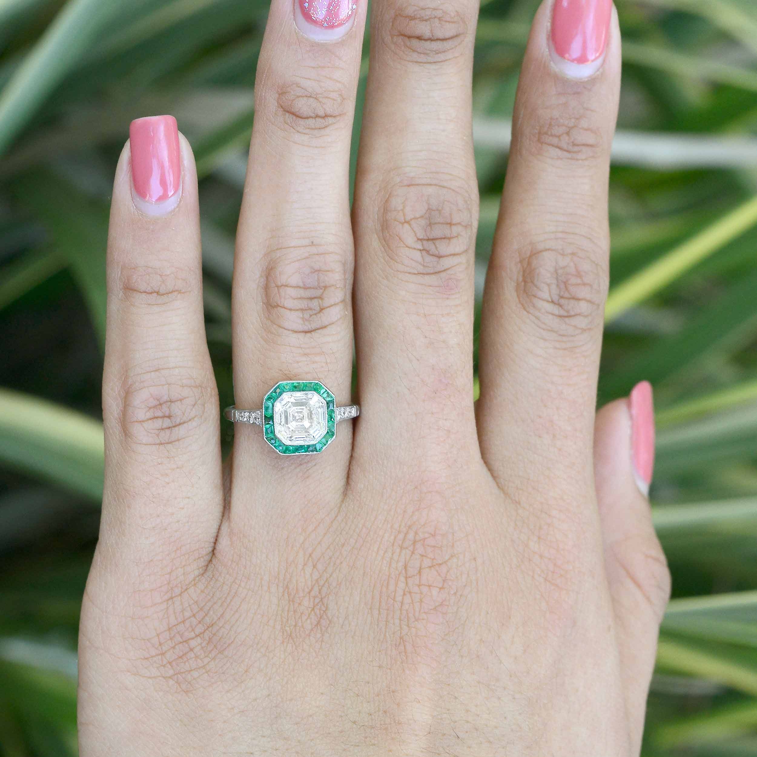 A two carat asscher cut diamond octagon engagement ring with emeralds.