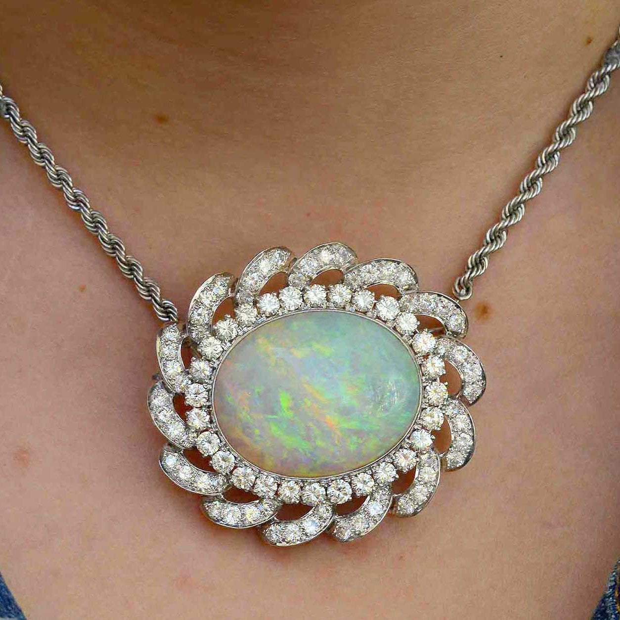 This cabochon oval opal is set in a diamond halo statement necklace.