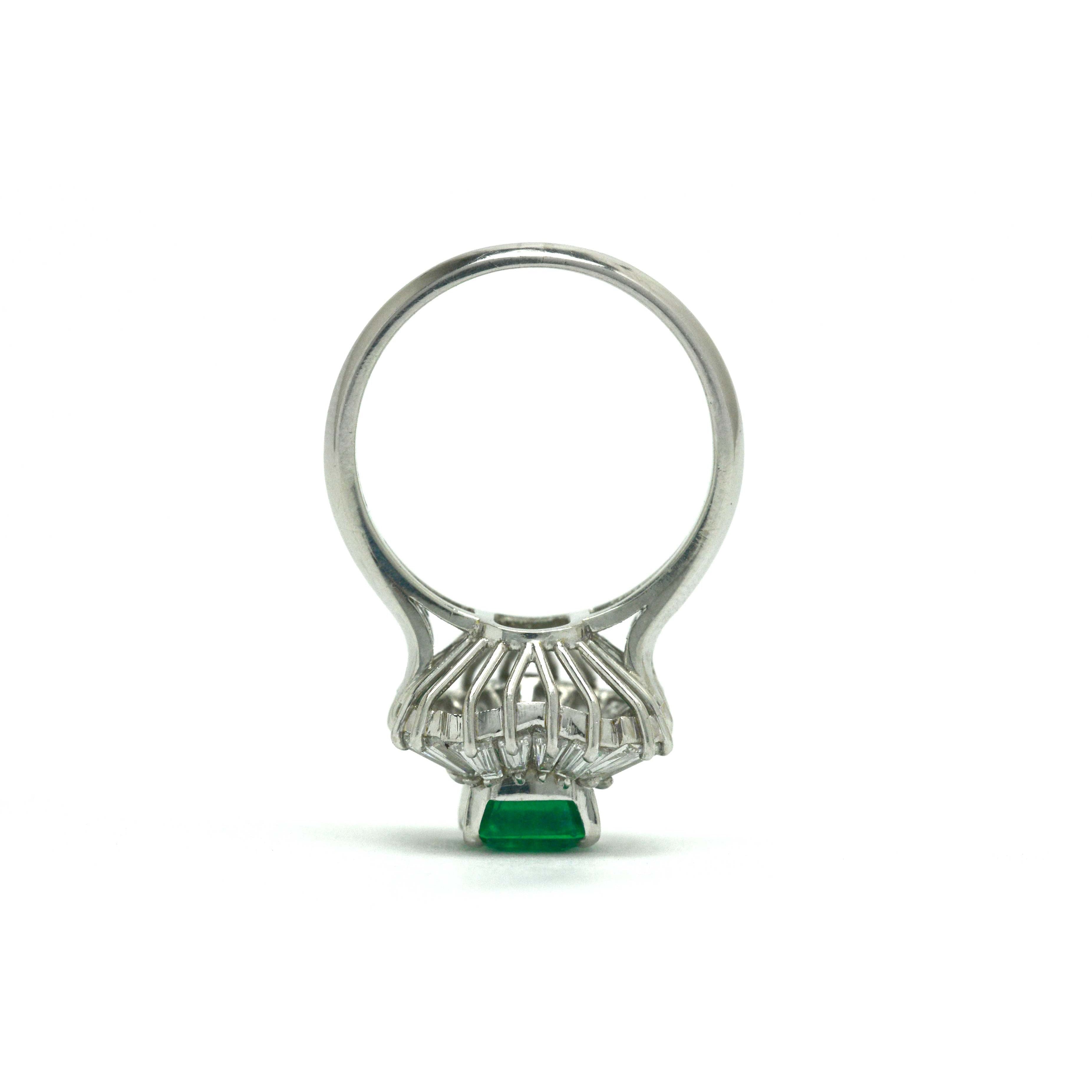 Baguette diamonds accent the 1 and half carat emerald in this platinum ballerina ring.