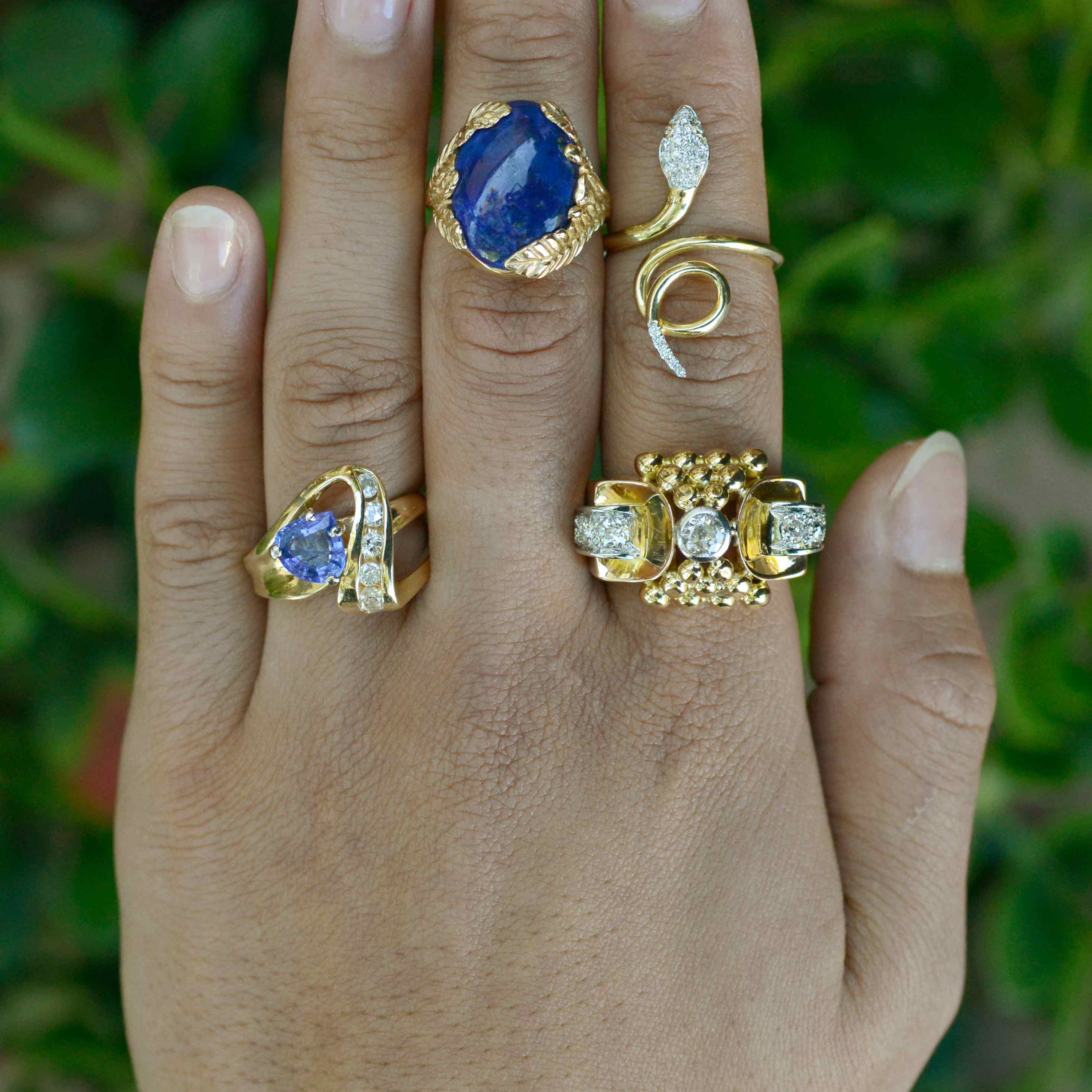 Modern gold cocktail rings set with diamonds and blue gemstones.