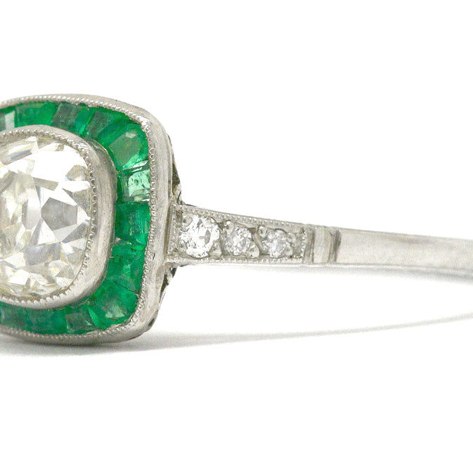 A rounded square diamond and emerald halo engagement ring.