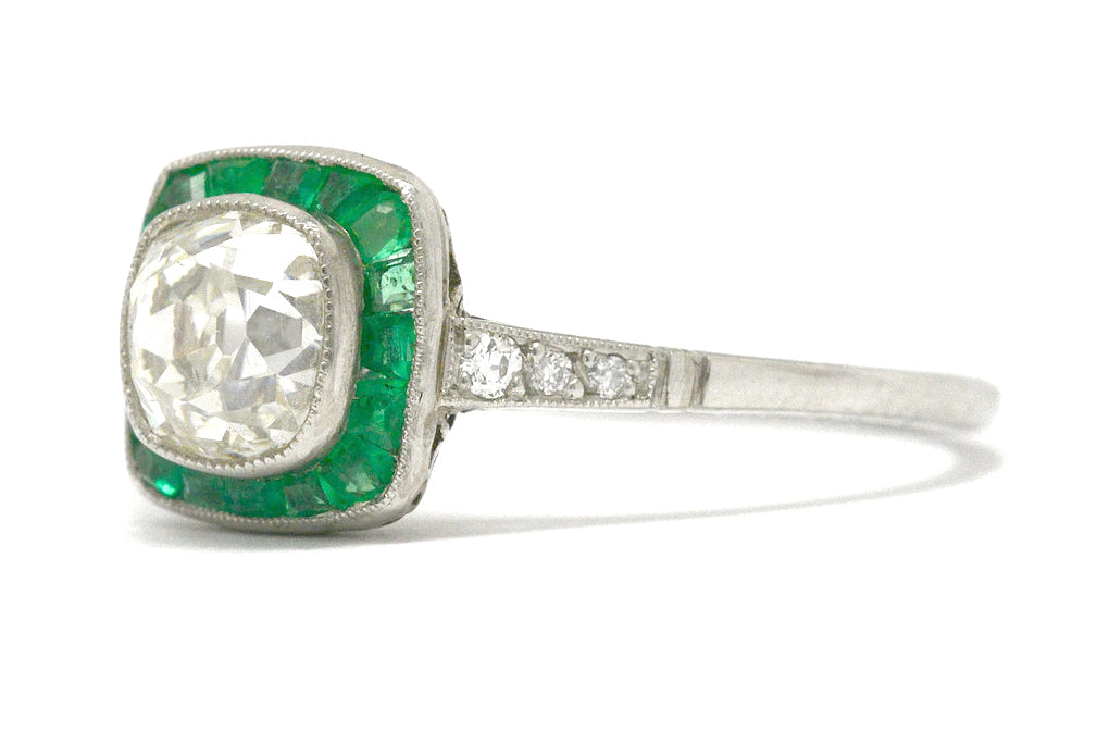 A rounded square diamond and emerald halo engagement ring.