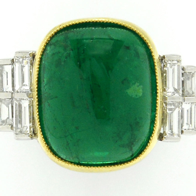 A highly-transparent, vivid green emerald set in a ring with 8 diamond accents.