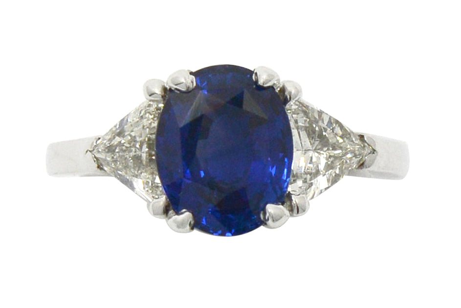 An oval 3 carat blue ceylon sapphire, three stone engagement ring.
