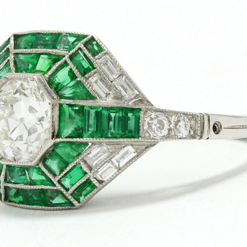 A unique platinum diamond mosaic engagement ring with diamonds and bright green emeralds.