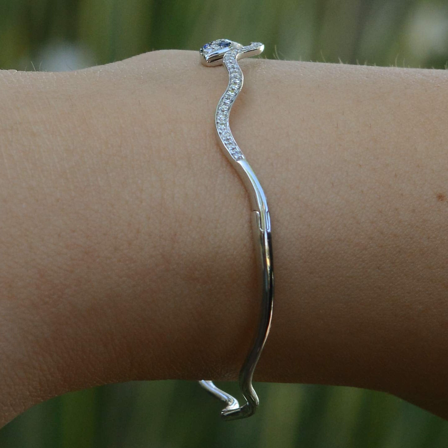 A curved white gold modern bangle bracelet.