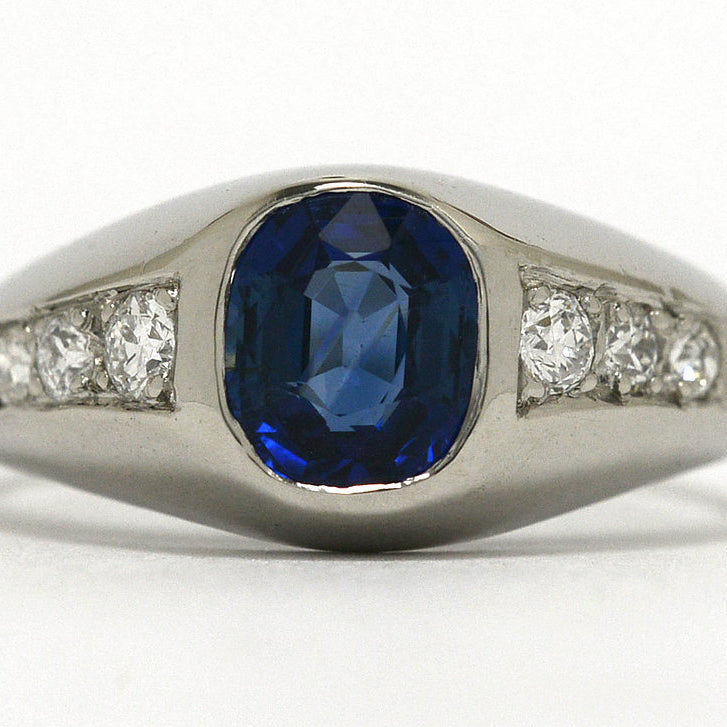 A cushion blue sapphire ring with 3 diamonds to both sides.