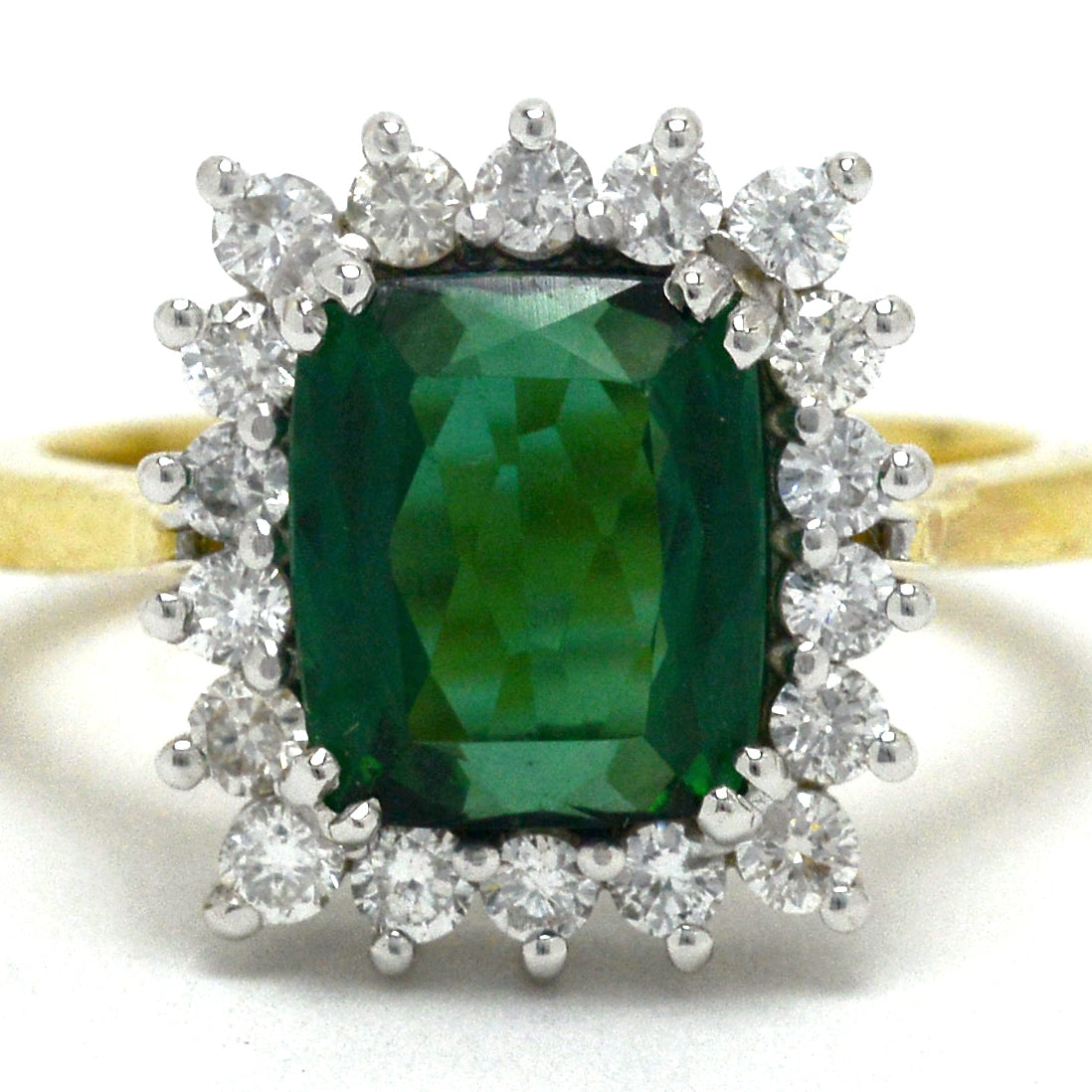 A Princess Diana style green tourmaline diamond target engagement ring.