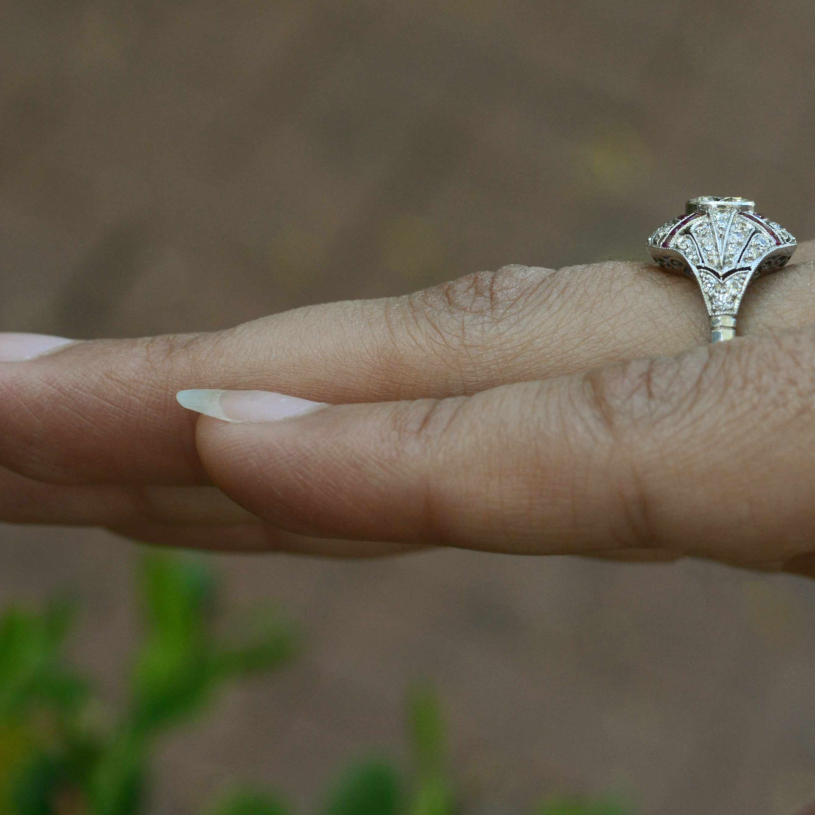 An Edwardian style round brilliant diamond engagement ring with ruby lines.