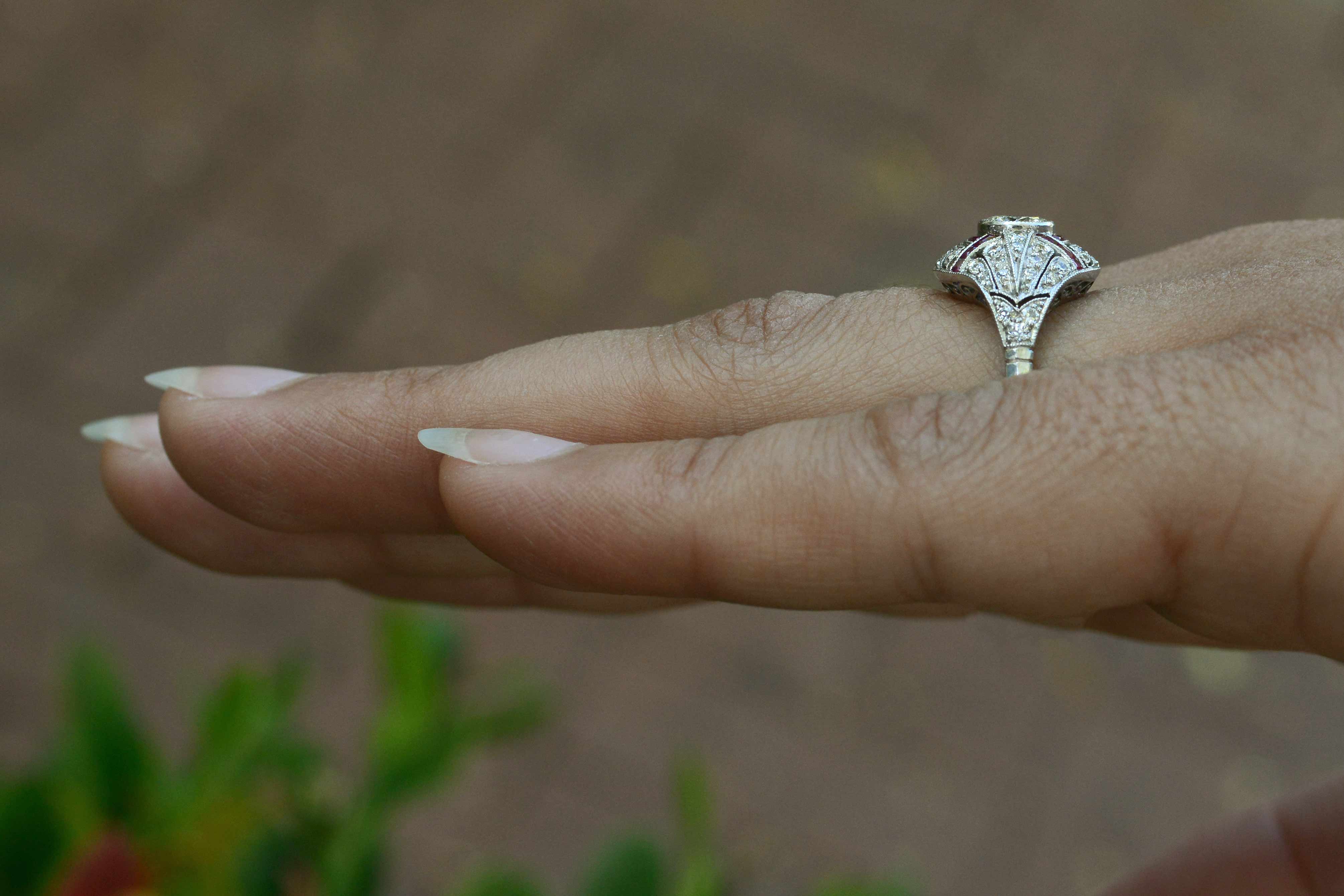 An Edwardian style round brilliant diamond engagement ring with ruby lines.