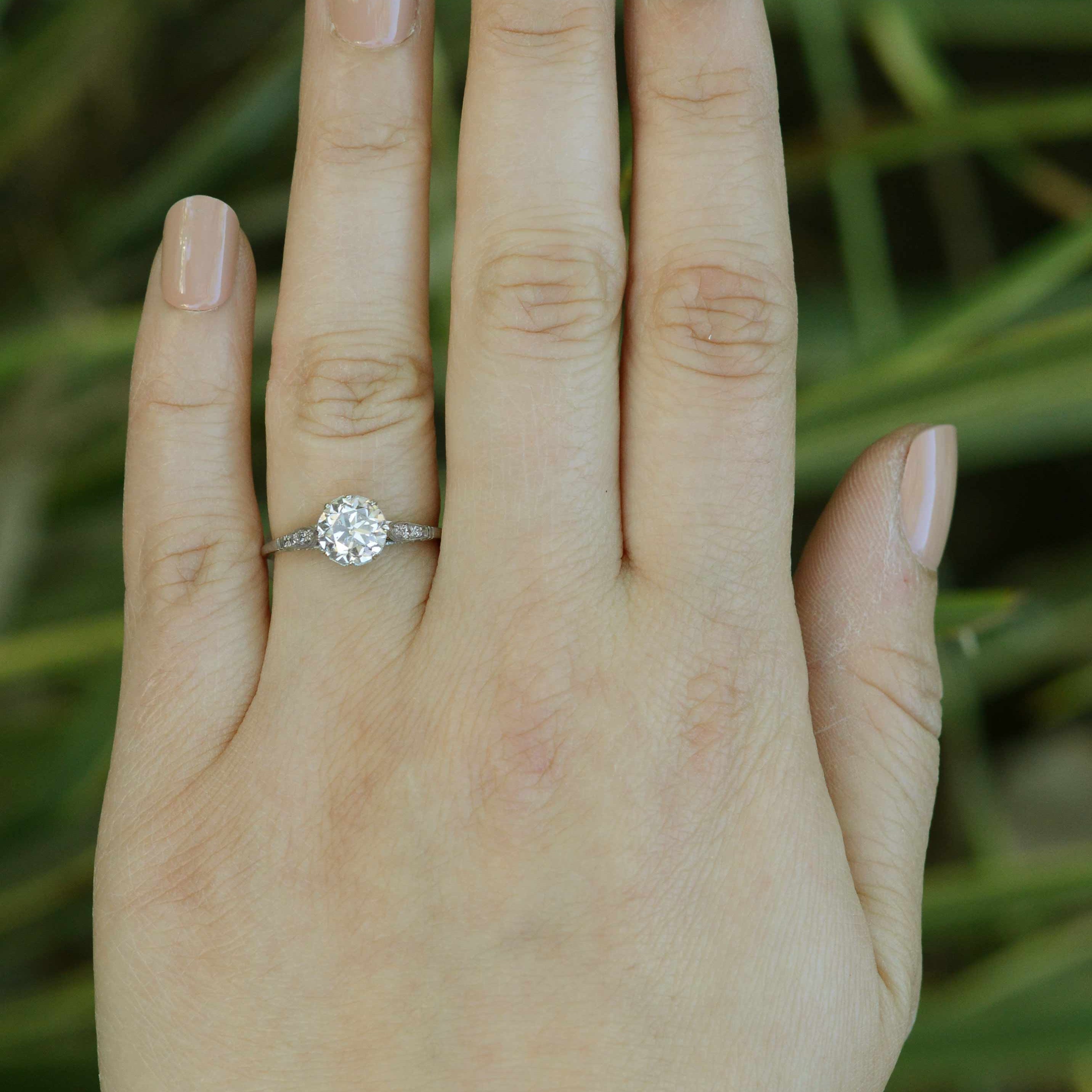 A large one carat diamond engagement ring with accent diamonds on the shoulder and setting.