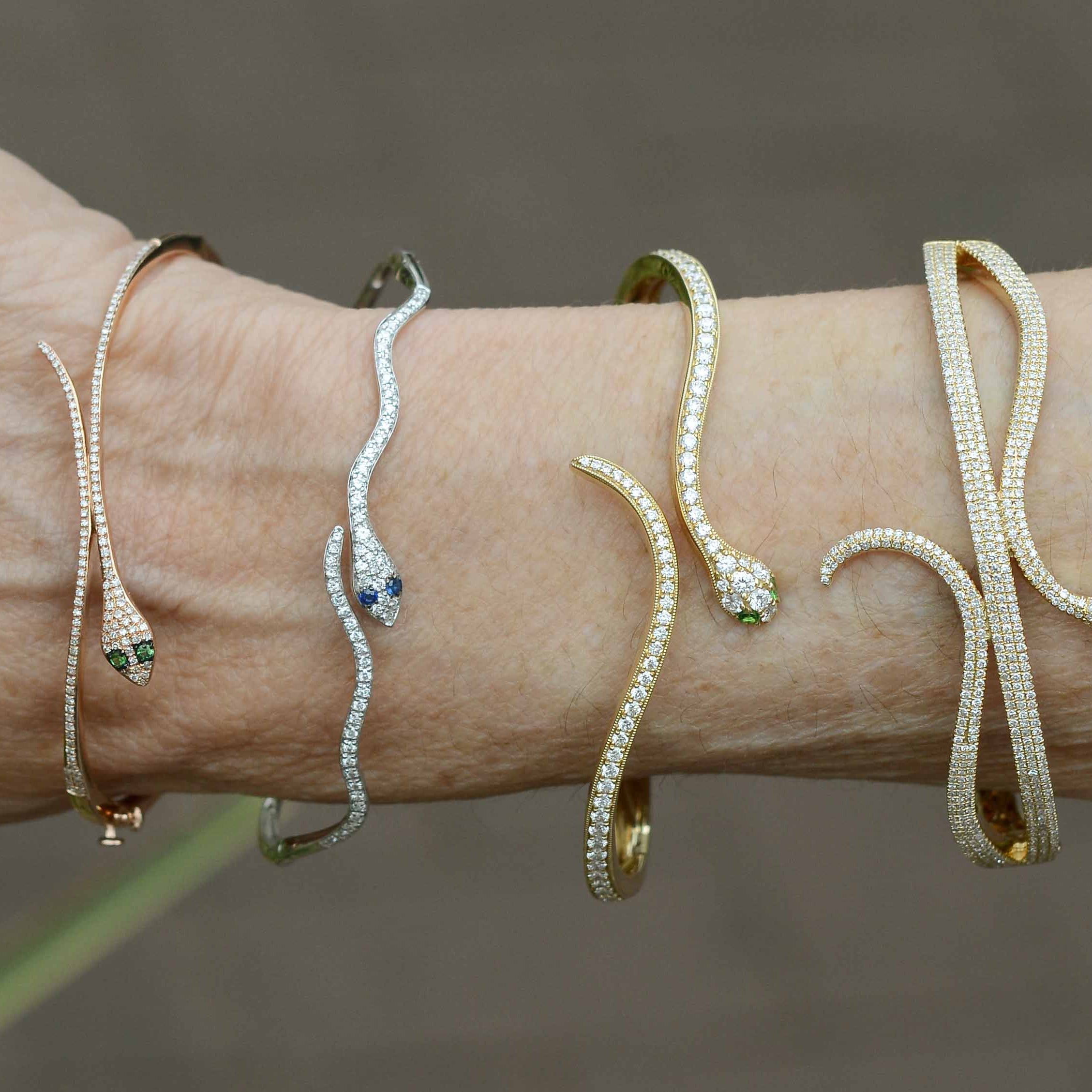 Four diamond and gold modern snake bangle bracelets.