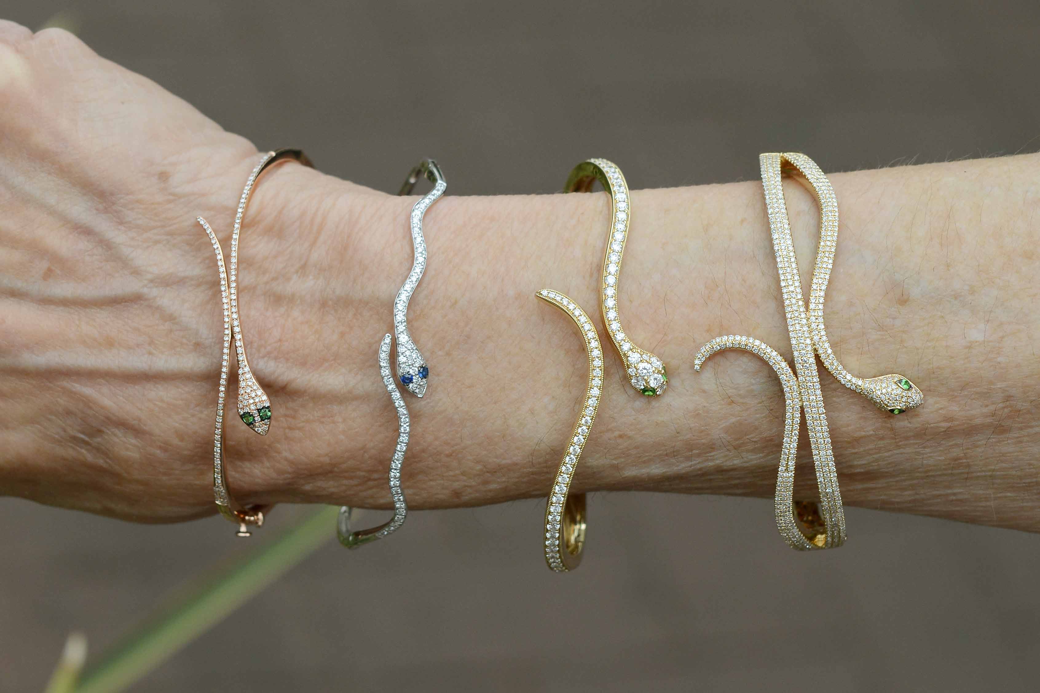 Four diamond and gold modern snake bangle bracelets.