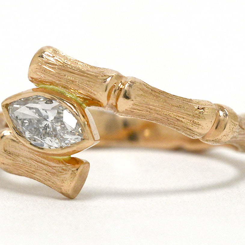 A rose gold diamond bamboo pattern solitaire ring.