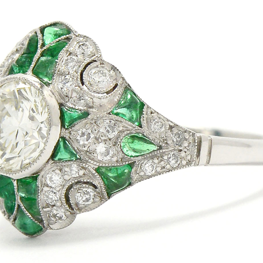 A nearly 1 carat transitional round diamond emerald engagement ring.