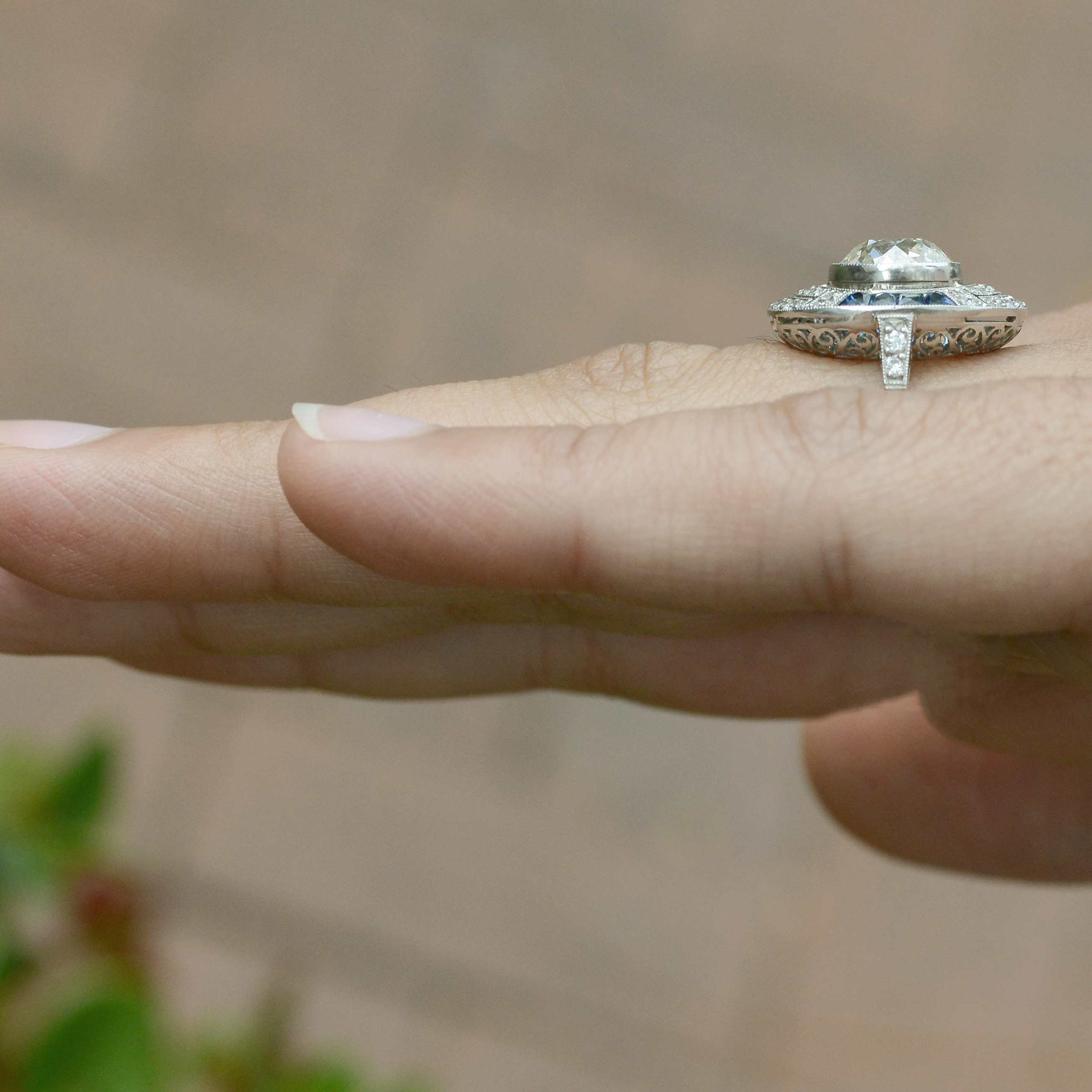French cut blue sapphires and round diamonds accent the main gem.