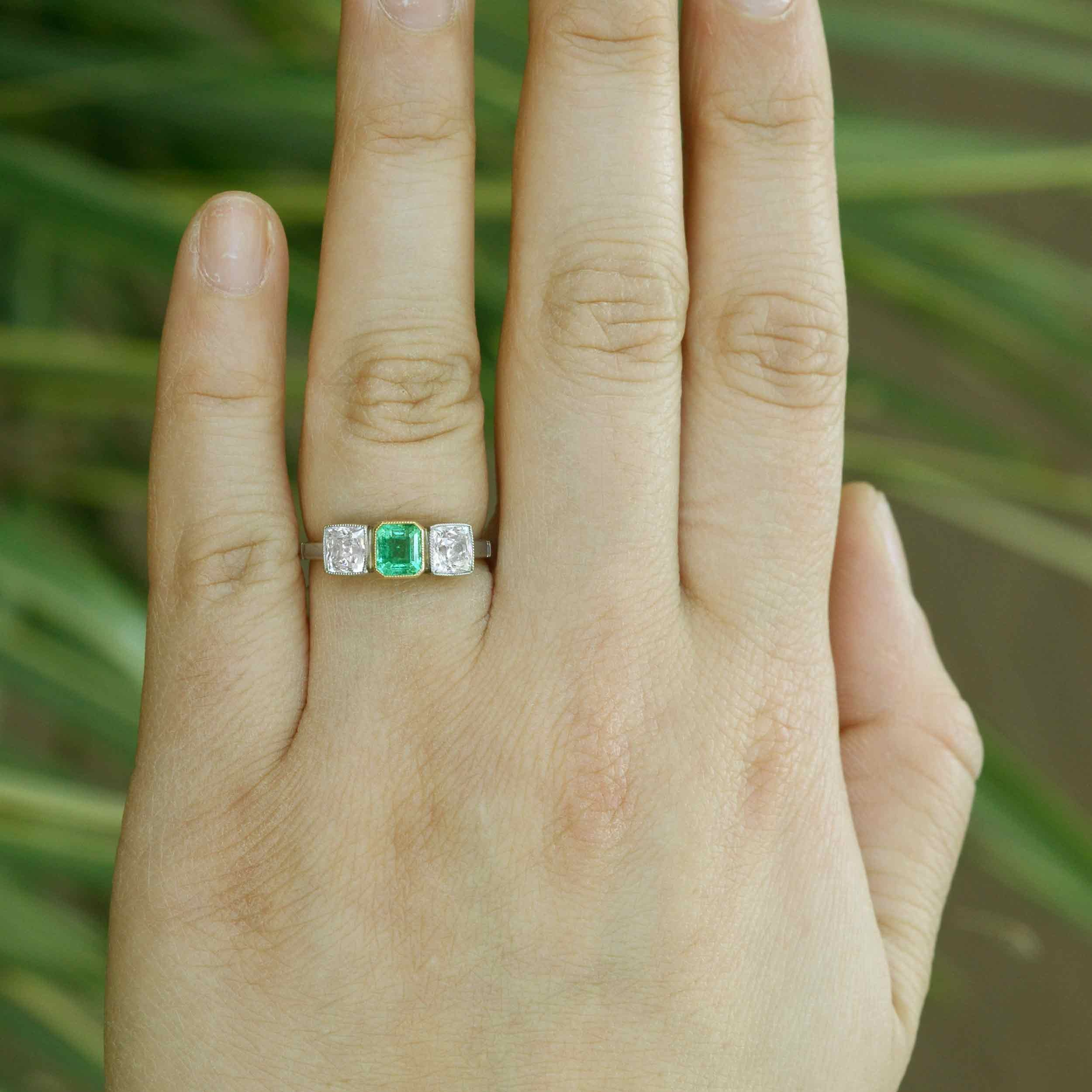 Platinum gemstone and two diamonds engagement ring.