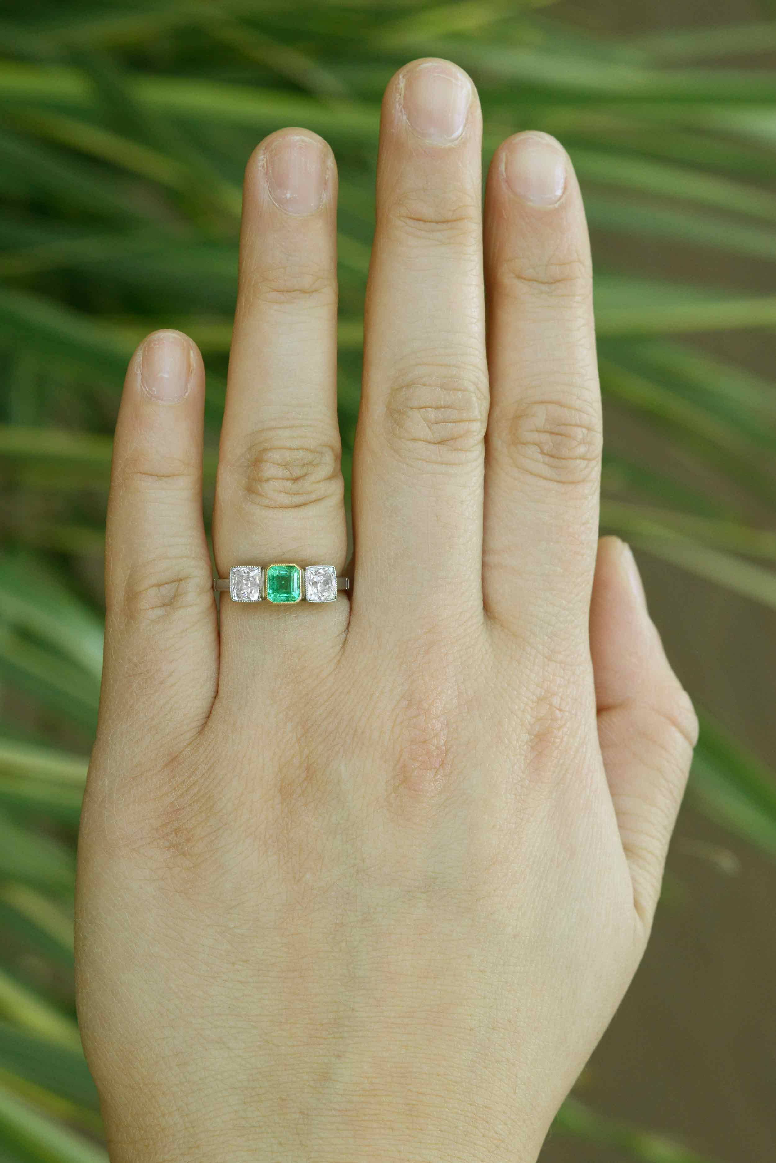 Platinum gemstone and two diamonds engagement ring.