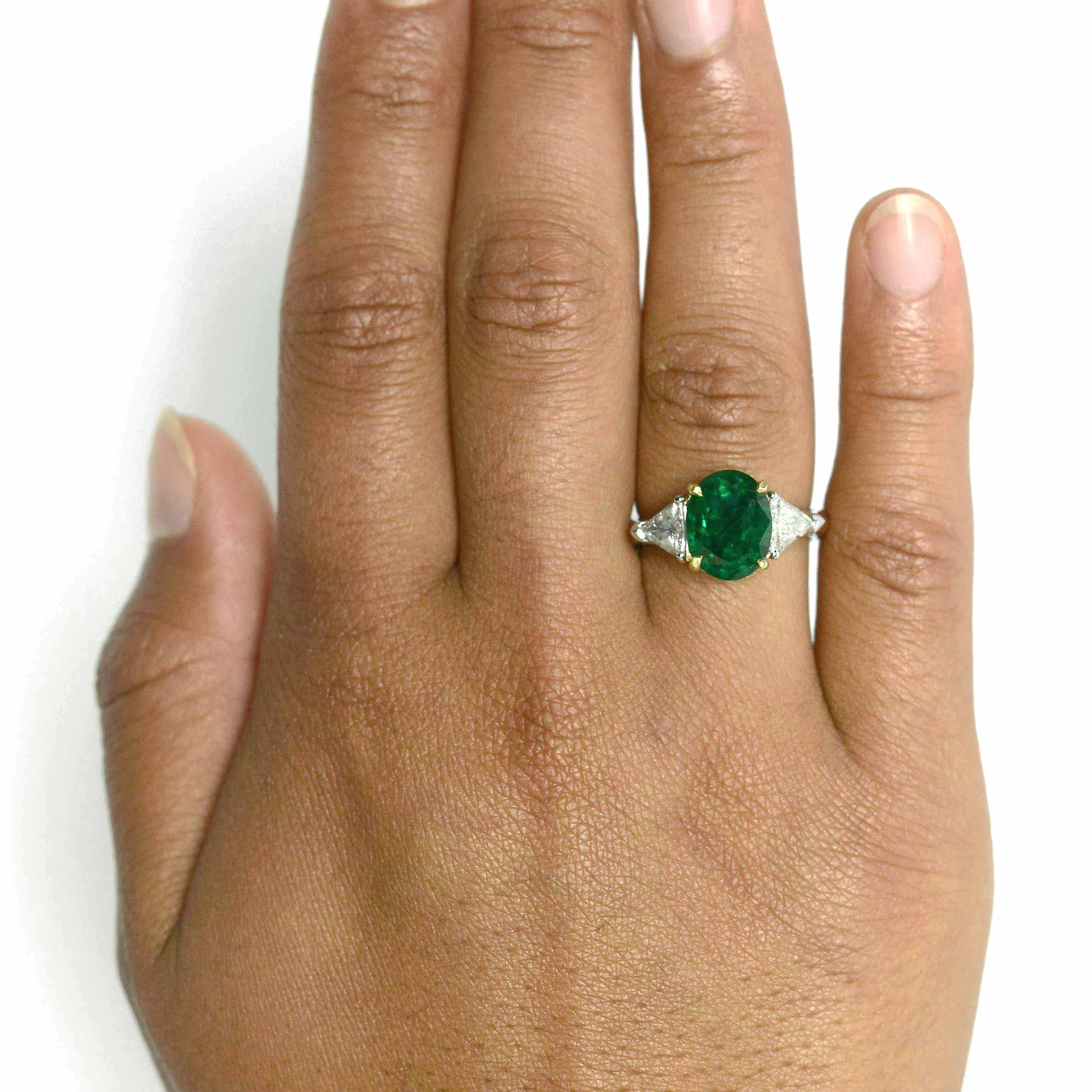 4 prongs secure the emerald of over 3 carats in this modern engagement ring.