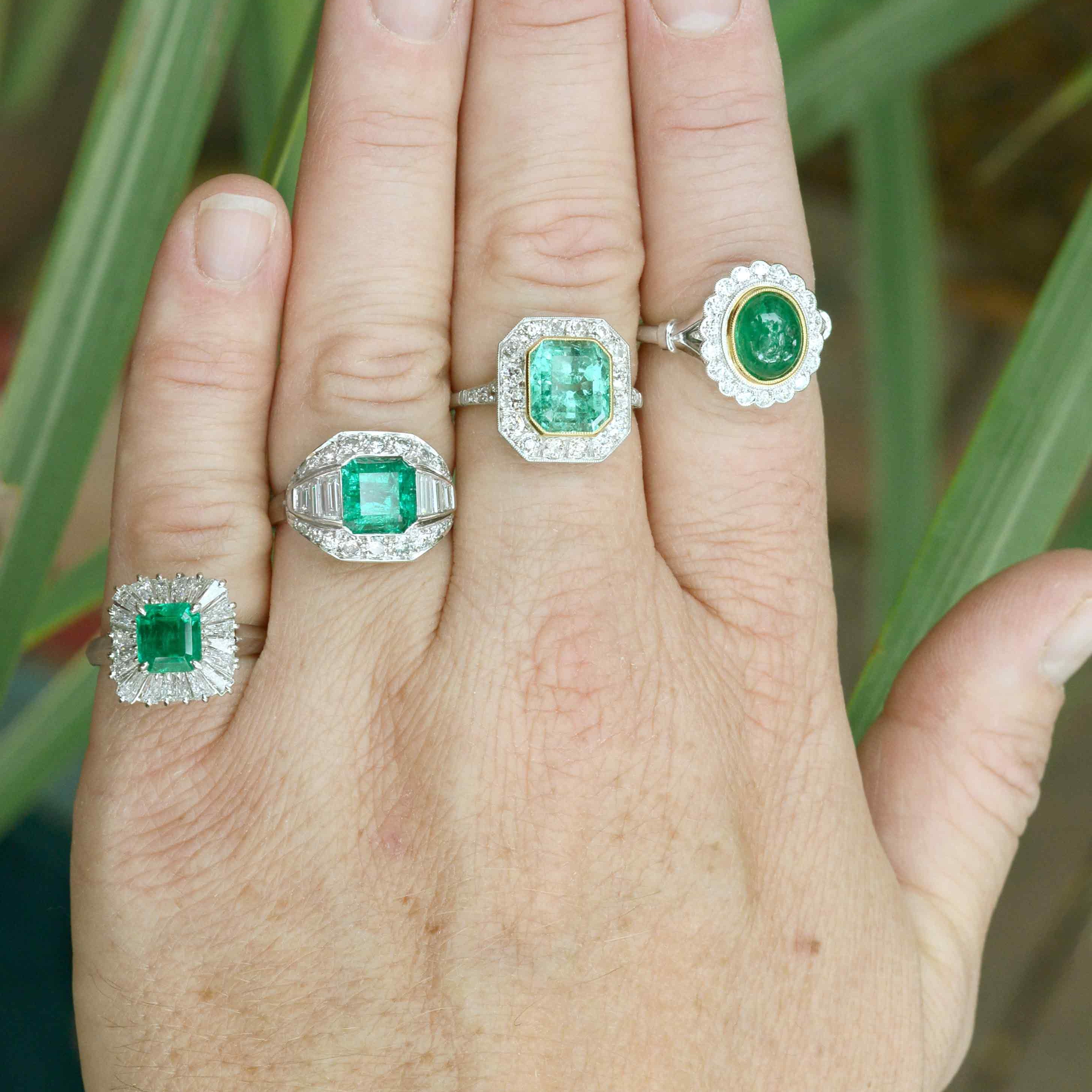 Emerald with diamonds, target and halo wedding rings.
