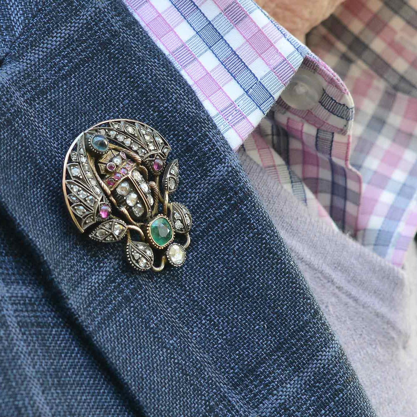 An antique, gold Victorian scarab beetle pin with a silver top.