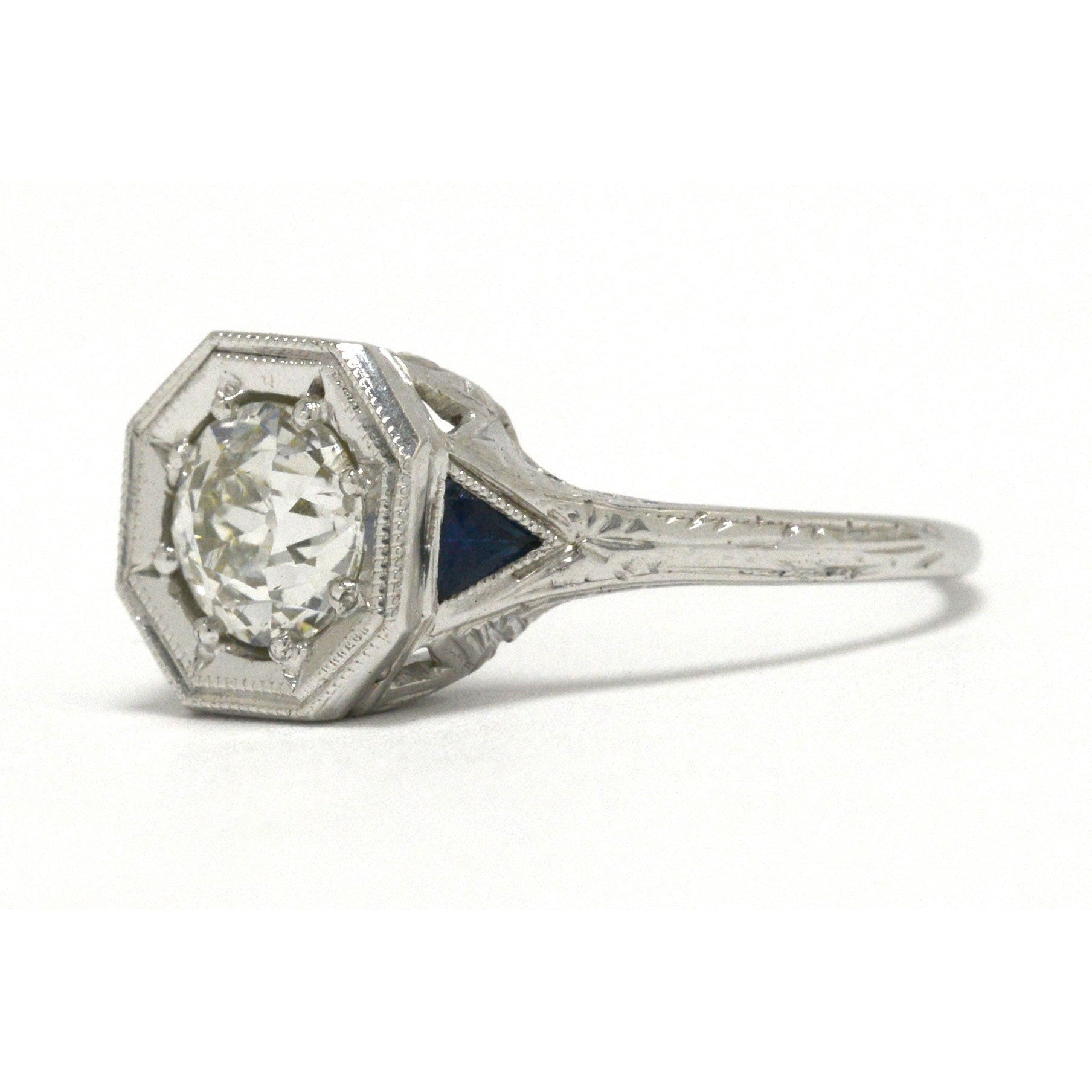 An antique old European cut diamond engagement ring with triangle sapphires.