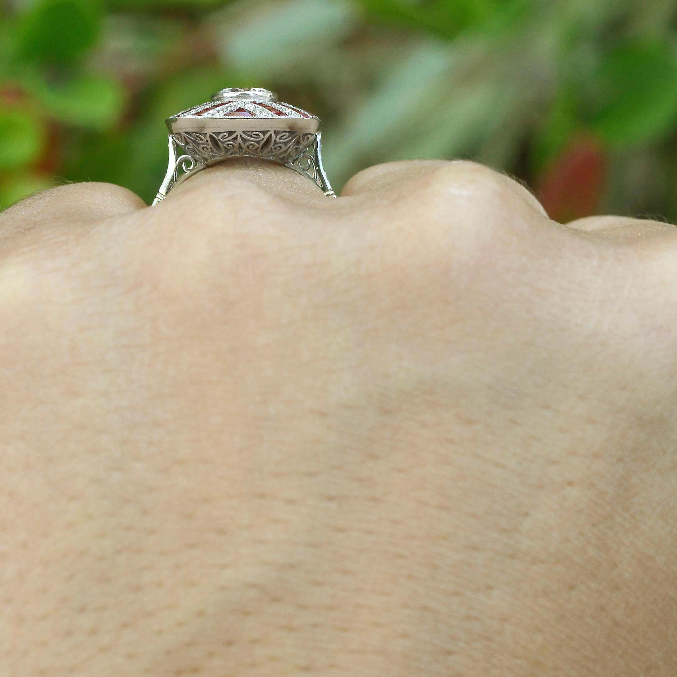 A stunning Art Deco diamond and ruby engagement ring with a filigree under gallery.