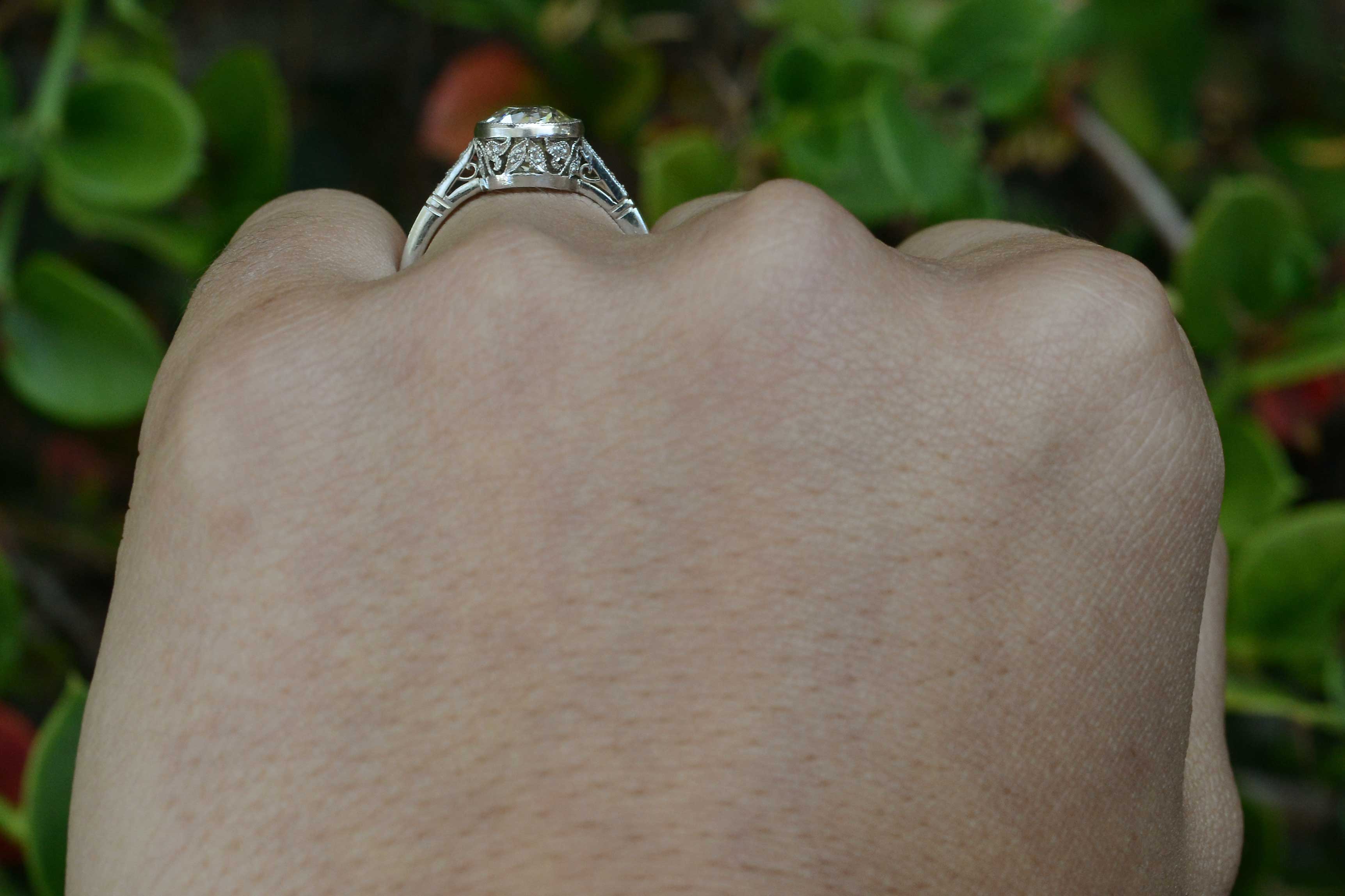 Floral bezel setting details are shown in this Art Deco diamond engagement ring.