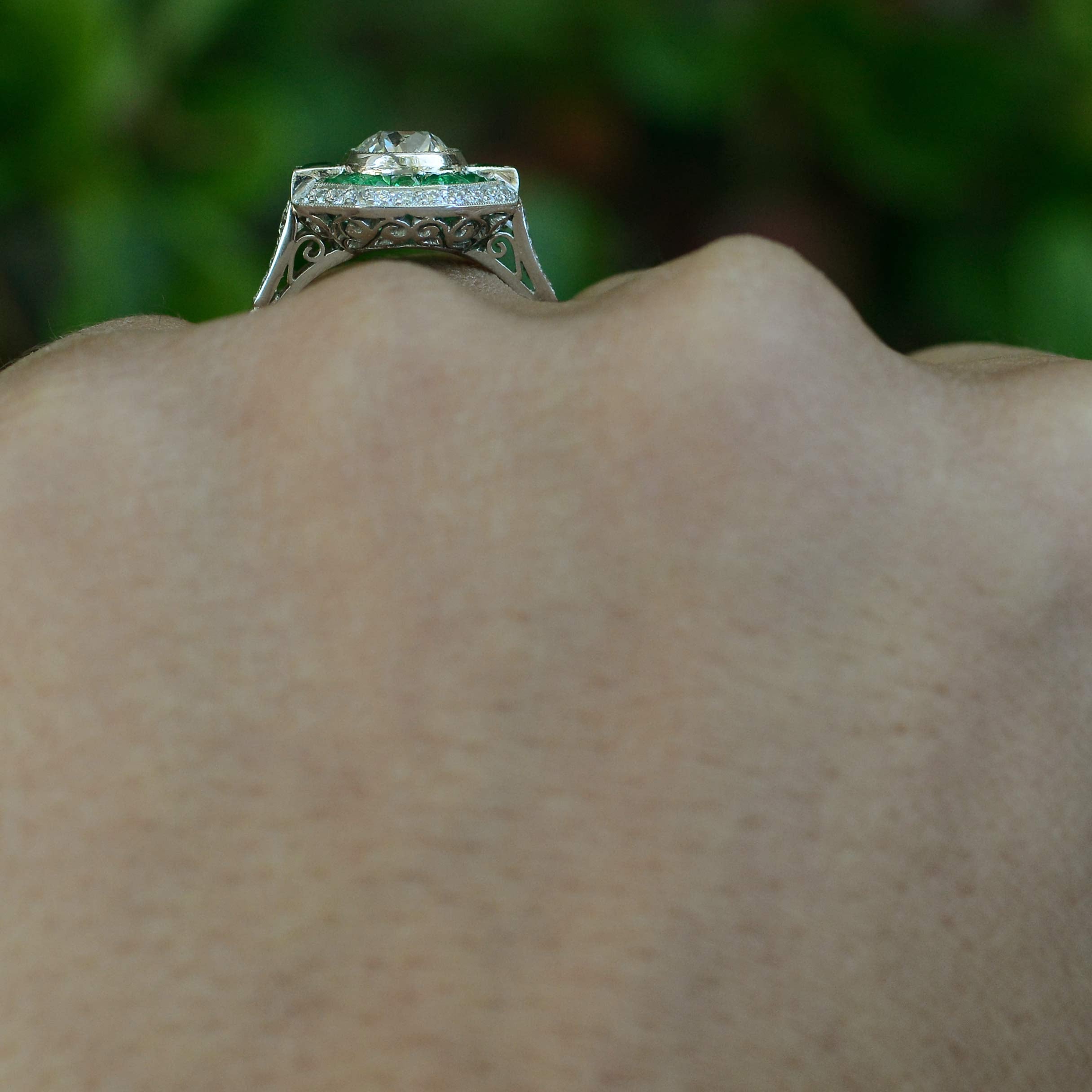 A hand crafted diamond emerald engagement ring, fabricated in the Art Deco style.