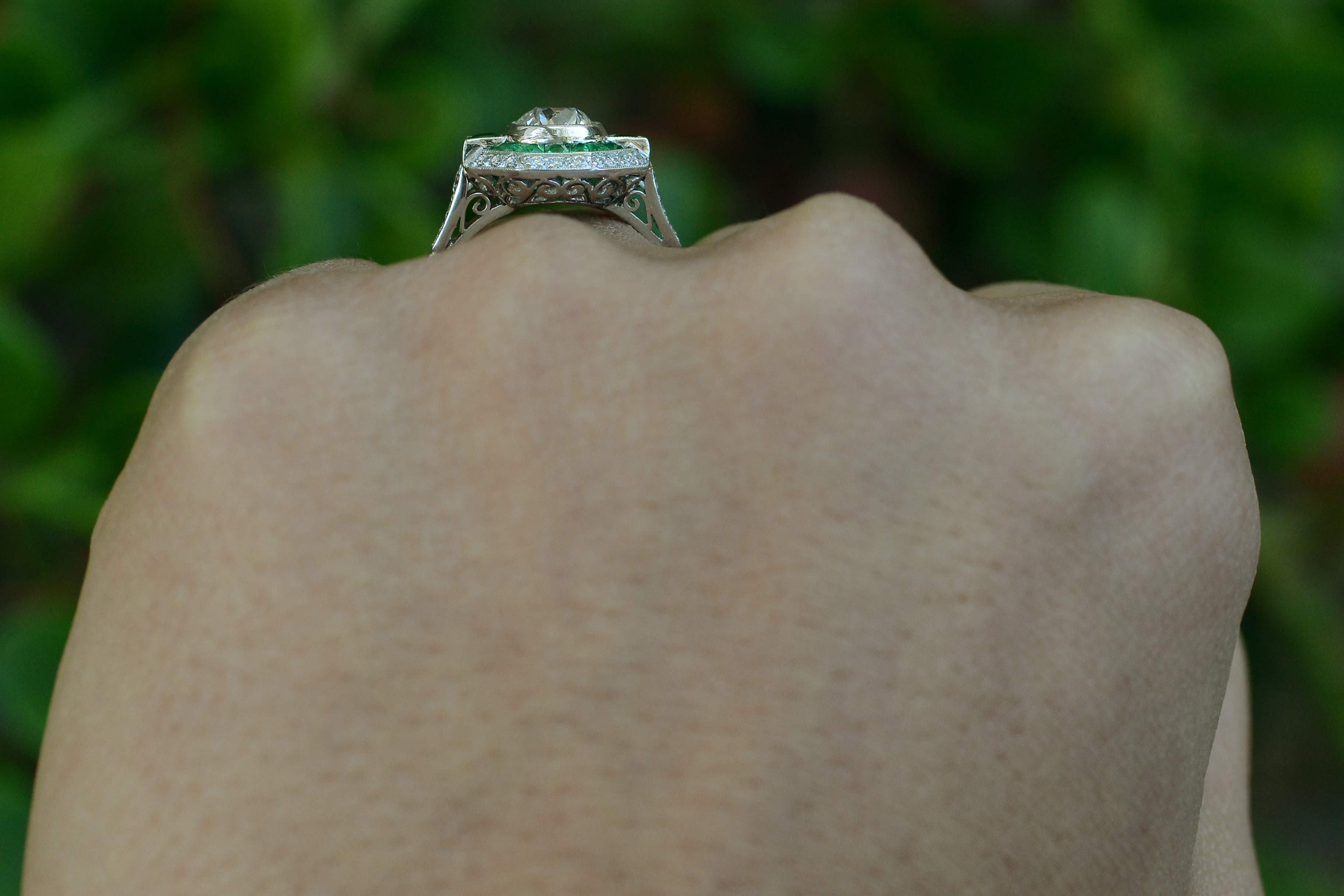 A hand crafted diamond emerald engagement ring, fabricated in the Art Deco style.