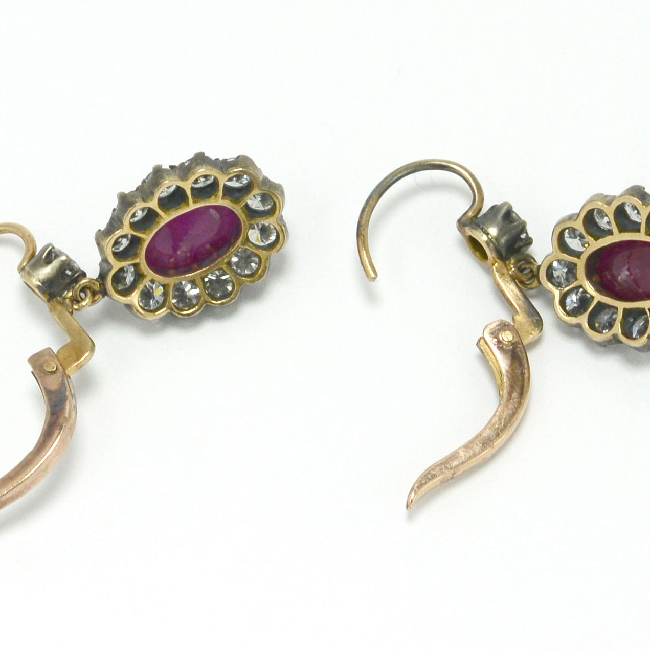 Silver topped 18k gold oval ruby diamond cluster earrings.